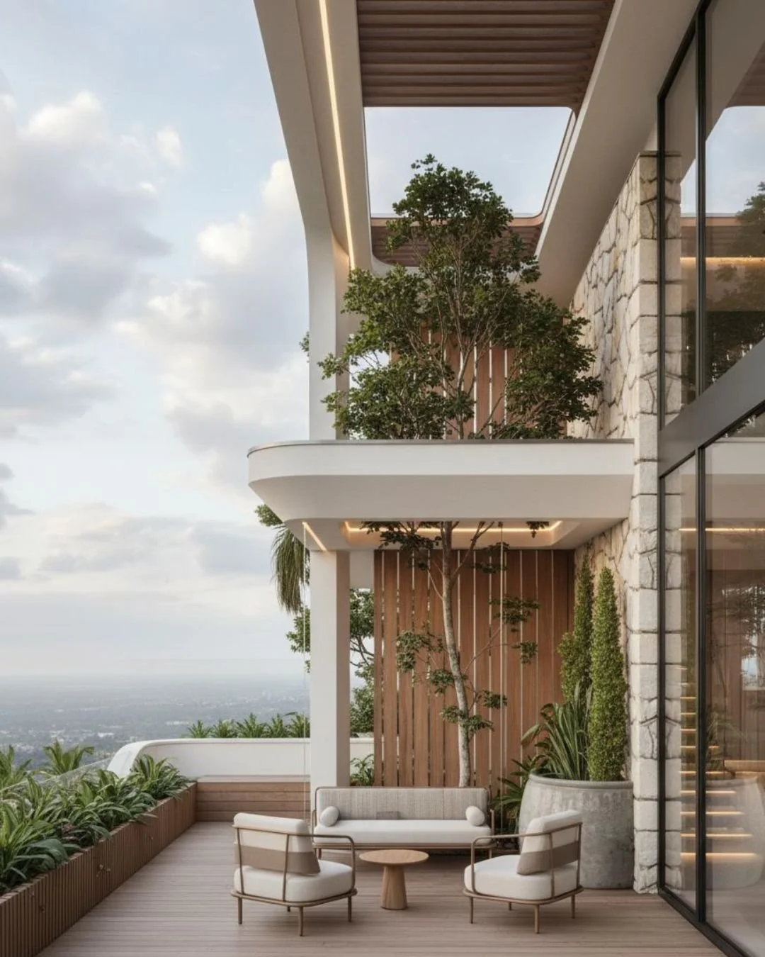 Modern balcony with outdoor seating, trees, potted plants, and city view in the background.
