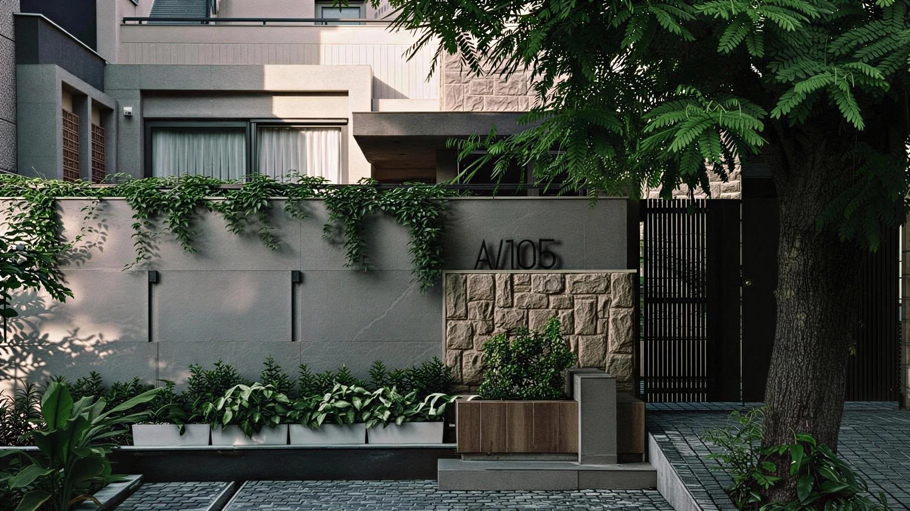 Modern house with gray and beige exterior, greenery in front, and a large tree on the right side.
