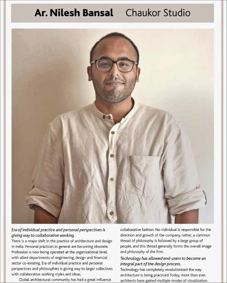 Portrait of Nilesh Bansal wearing glasses and a beige kurta, standing against a plain wall, with a slight smile.
