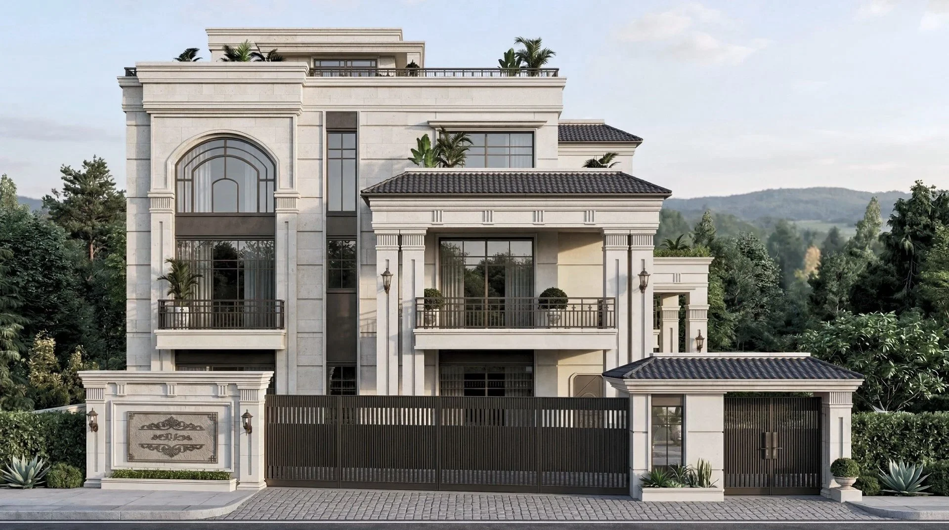 Luxury multi-story house with beige exterior, large arched and rectangular windows, ornate columns with decorative trim, balconies with black metal railings, lush green plants, and a gated entrance, set against a backdrop of hills and trees.