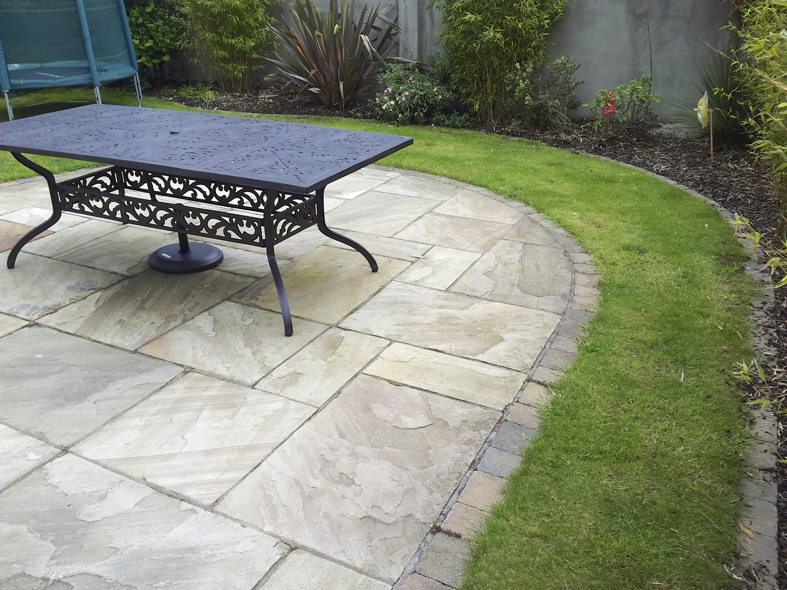 Sandstone patio and curving lawn