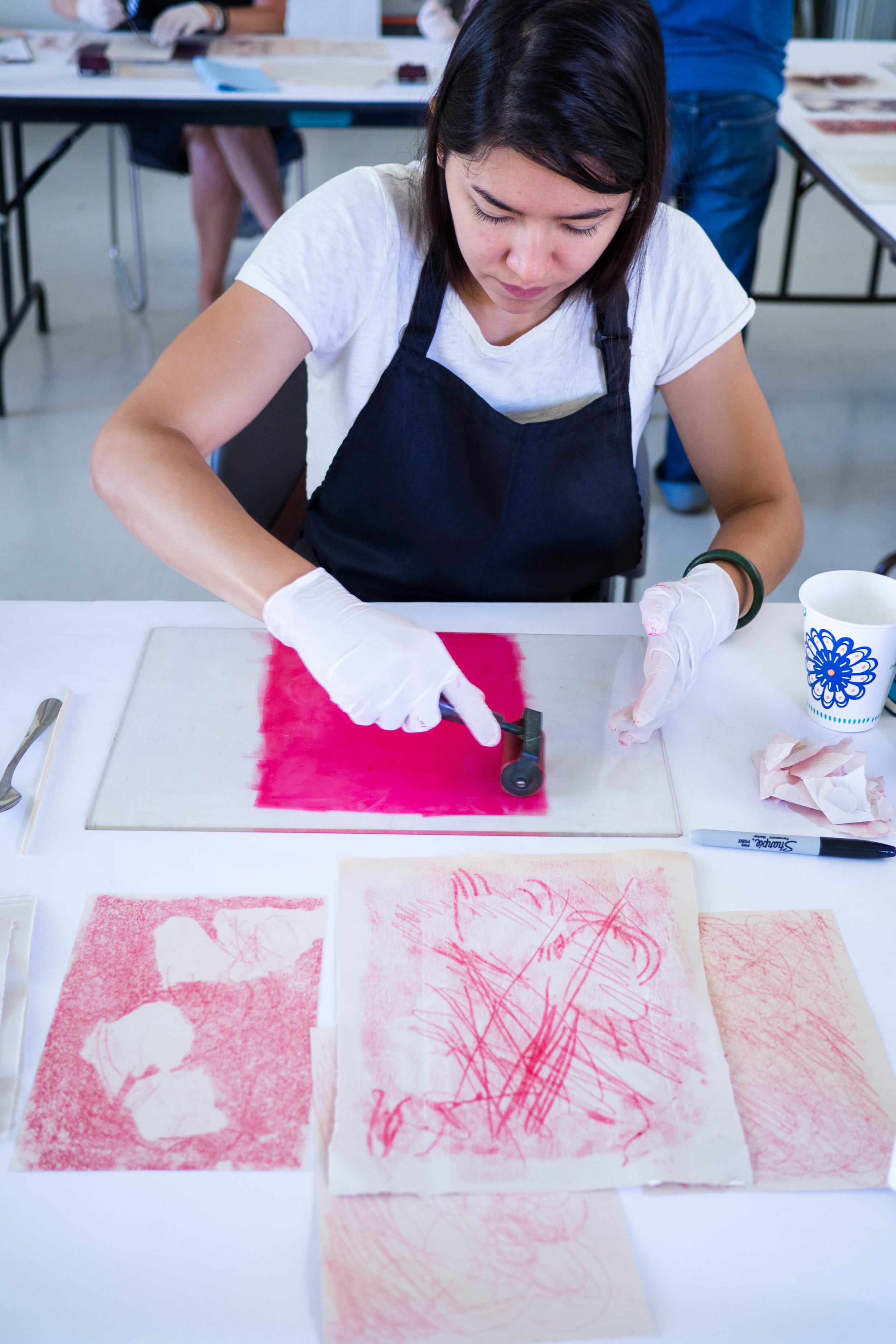 Workshop participants roll out Akua Liquid Pigment with a brayer.