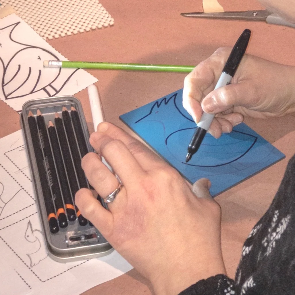 A participant reinforces her drawing with sharpie as she finalizes her design.
