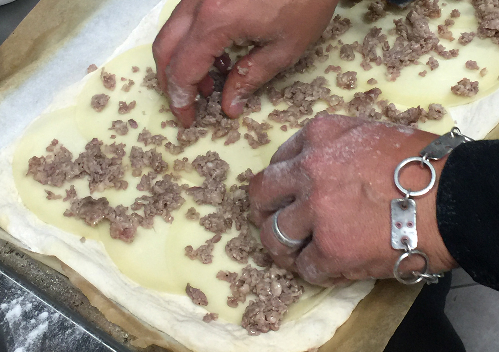 prepping sausage pizza