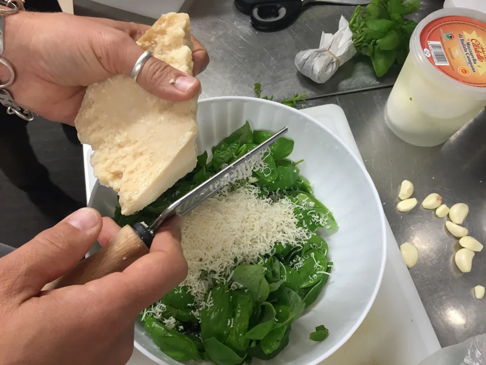 grating parmiggiano reggiano by hand for pesto