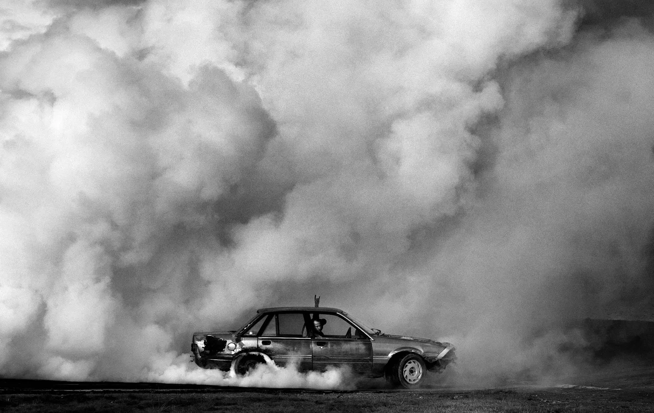Barry Marriner tears through the tyres of his old Holden during the annual burnout contest in Huntly, rural New Zealand. 