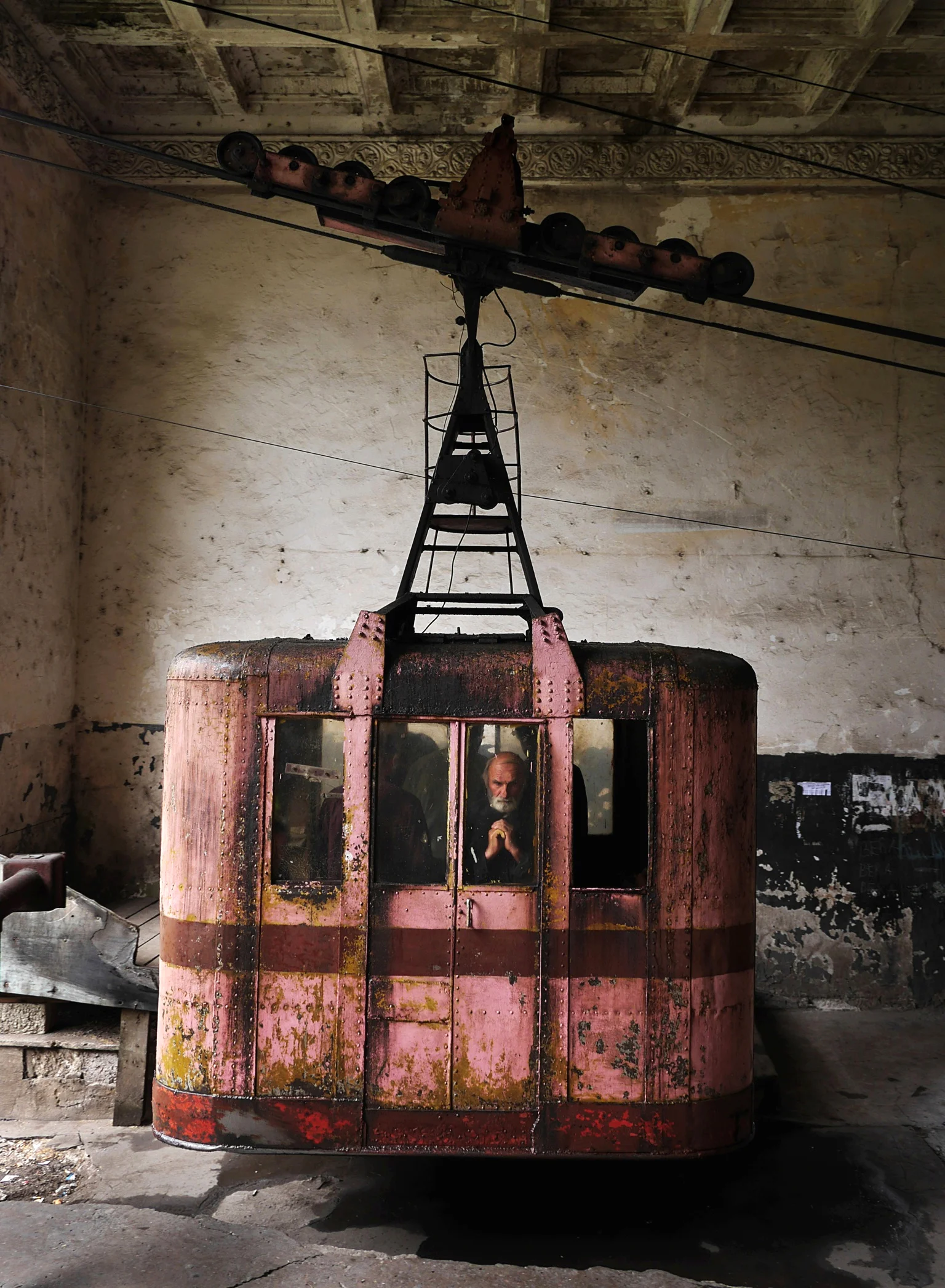 A local lost in thought as a cabin of Tramway 25 docks. This was the first passenger tramway in the USSR and has run almost continuously since 1954. 
