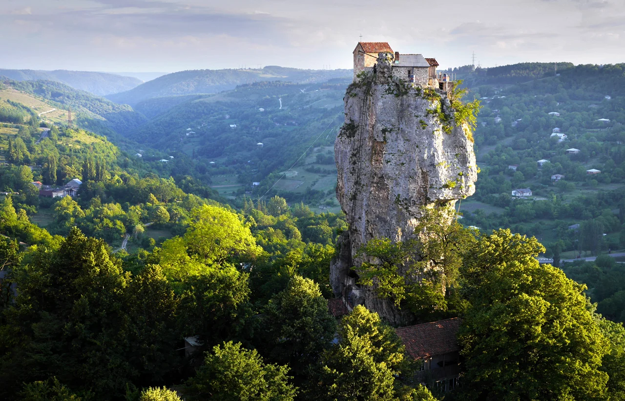 The Katskhi Pillar, Georgia. A monk (standing directly under the terracotta roof) has lived atop the pillar for the past 21 years in order to live "closer to God". Click here for the story. 