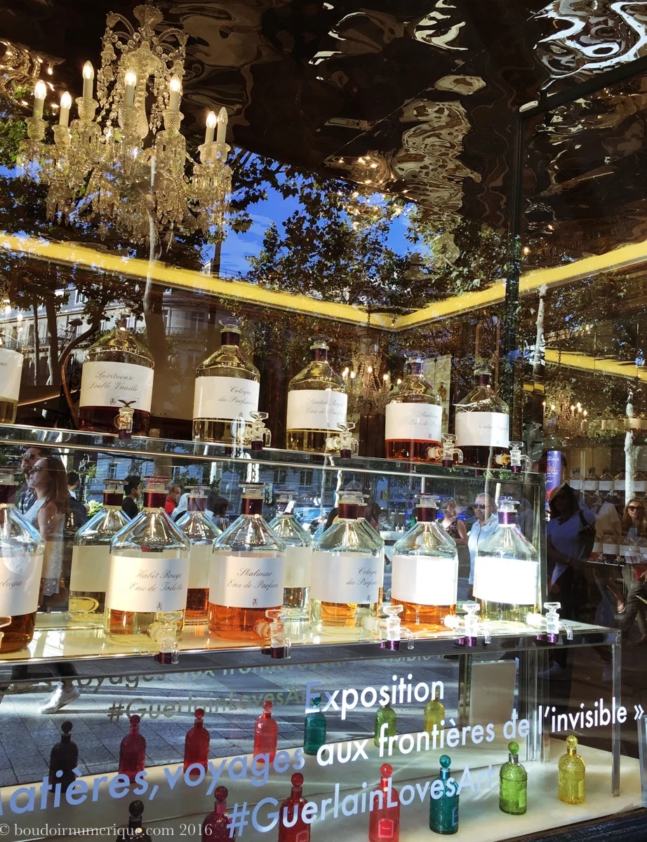 Vitrine de la boutique Guerlain des Champs-Elysées annonçant l'exposition "Matières, voyages aux frontières de l’invisible"