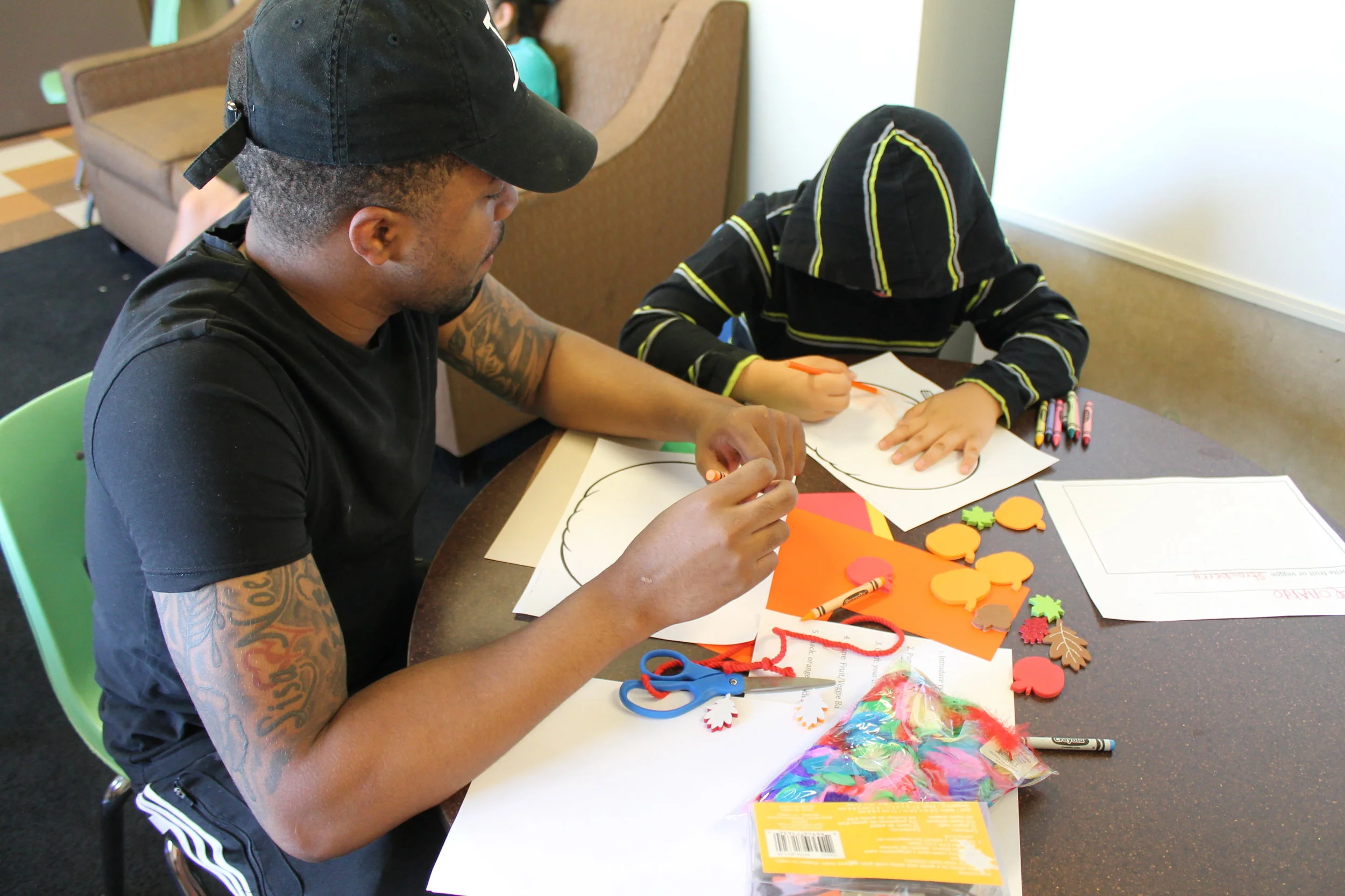 A volunteer coaching one of the shyer children as they shared about school and favorite foods.