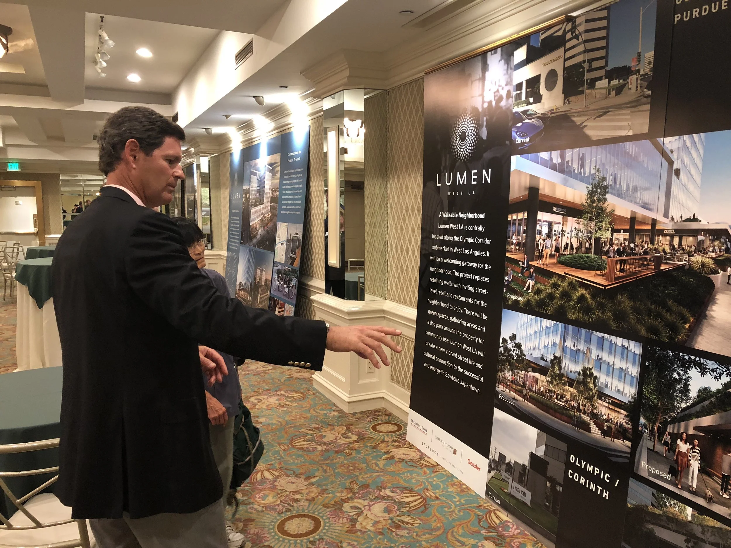 Developer Howard Cook points out details on the giant renders during the Trident / Lumen open house on Tuesday. The project will feature open floor plan offices, retail, and restaurants. The developers intend to find two large tenants to occupy the office spaces in the building. 