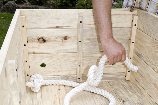 Starting in a corner on the inside of the casket, feed the rope through one of the handle holes.