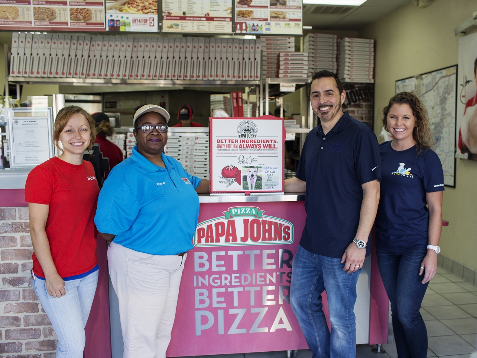 Promoting the collaboration between A Life to Live and Papa John’s are (from left) Magan Gonzales, A Life to Live co-founder and program director; Phebe Hayes, Papa John’s Baytown store manager; Adam Garza, director of marketing for Papa John’s Houston; and Preslie Cox, A Life to Live marketing coordinator and box-top flyer designer.