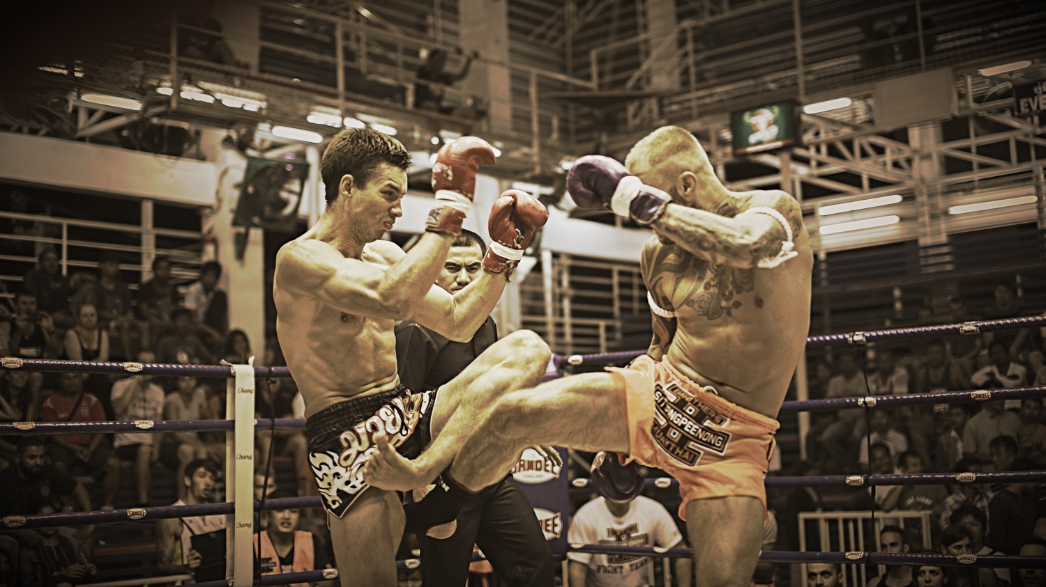 Head Muay Thai instructor Kris Barras fighting in Thailand (orange shorts)
