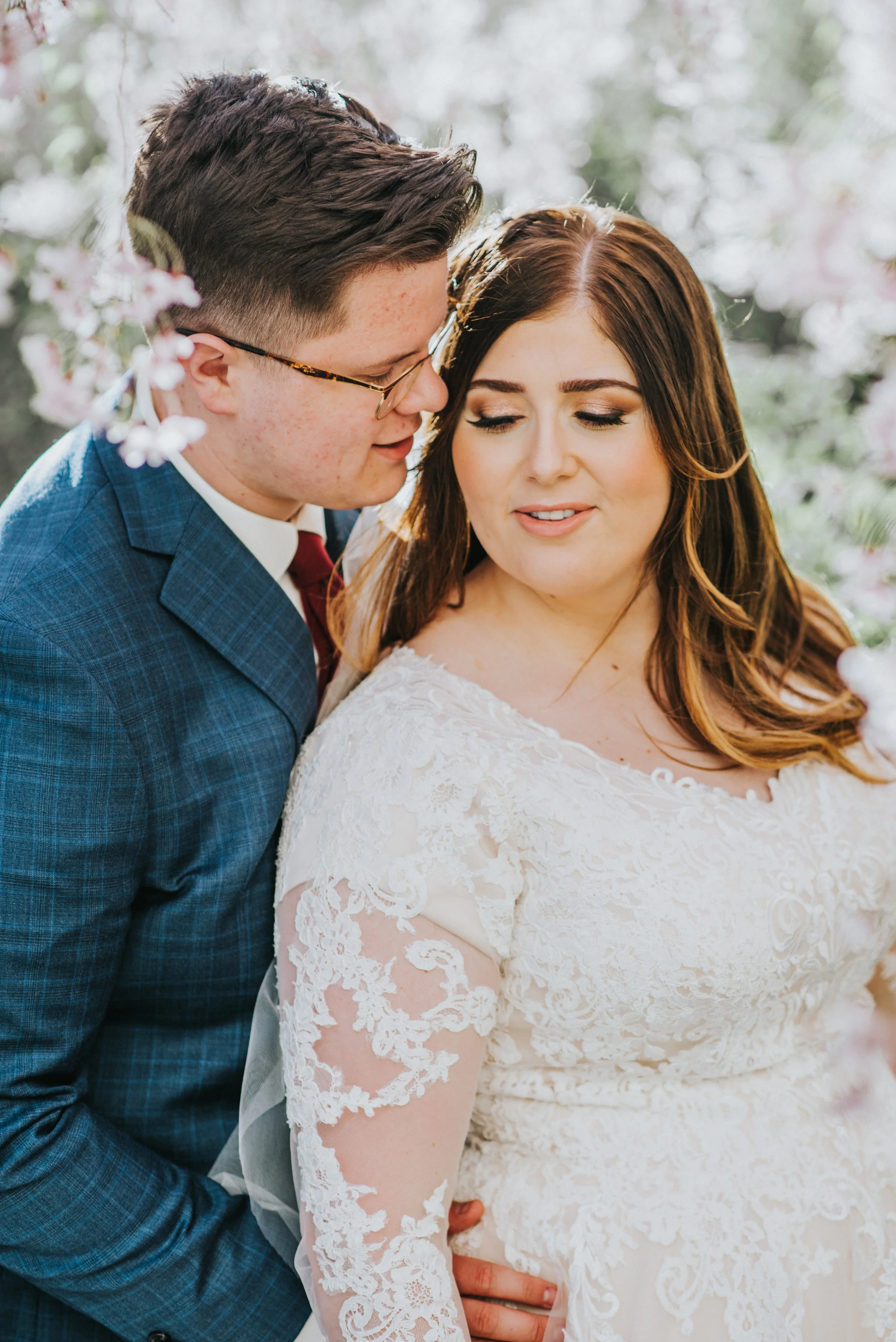  in the blossom filled trees formal wedding photo shoot session unique couple picture inspiration romantic beautiful couple long sleeve lace dress wedding dress inspiration wedding hairstyle goals groom suit inspiration beautiful wedding pictures lds