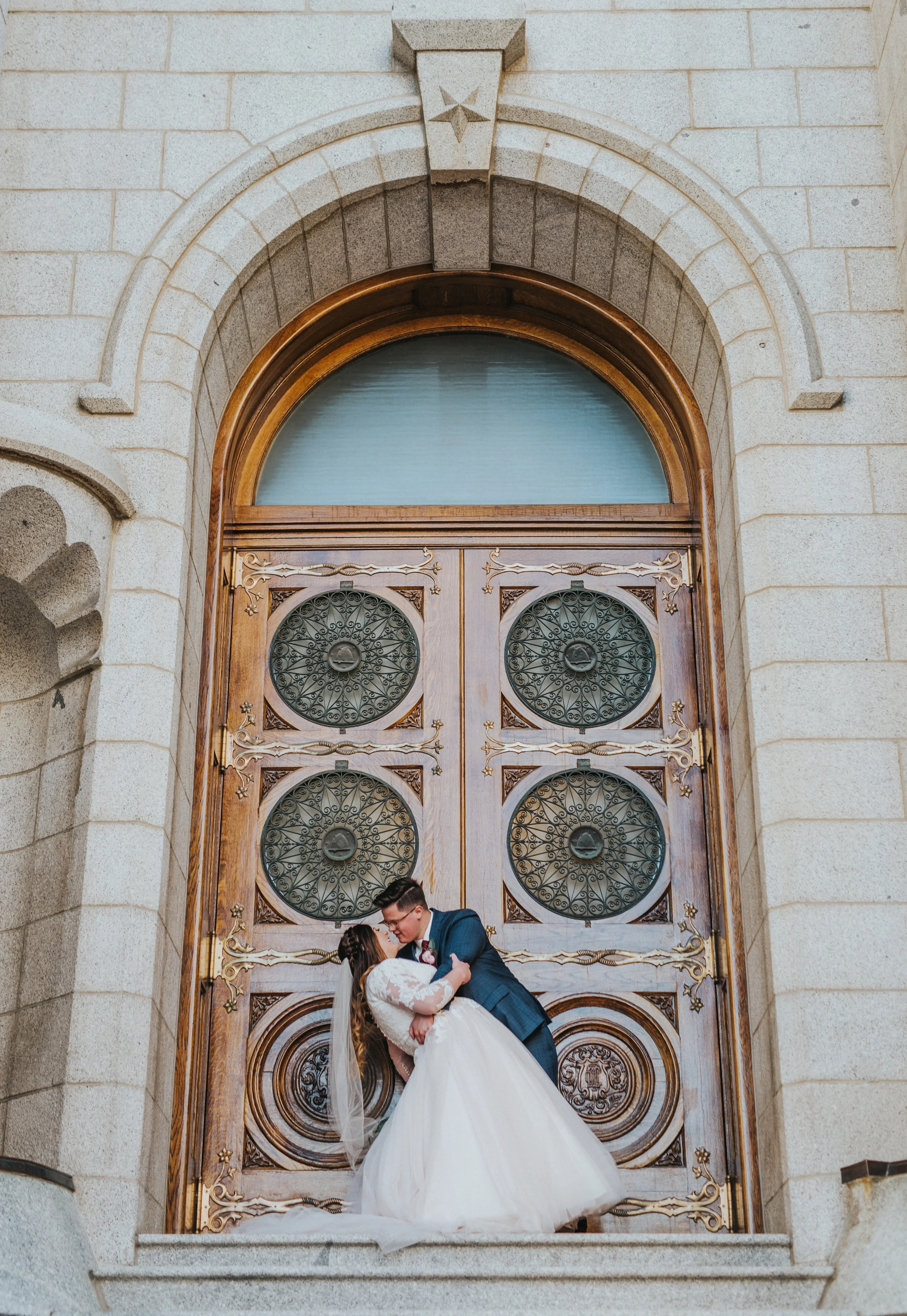  beautiful dip kiss in front of the gorgeous temple doors kissing couple pose inspiration beautiful wedding dress temple doors salt lake city temple formal wedding photo shoot inspiration  utah #ldswedding #mormon #utah #saltlakecity #formalwedding #