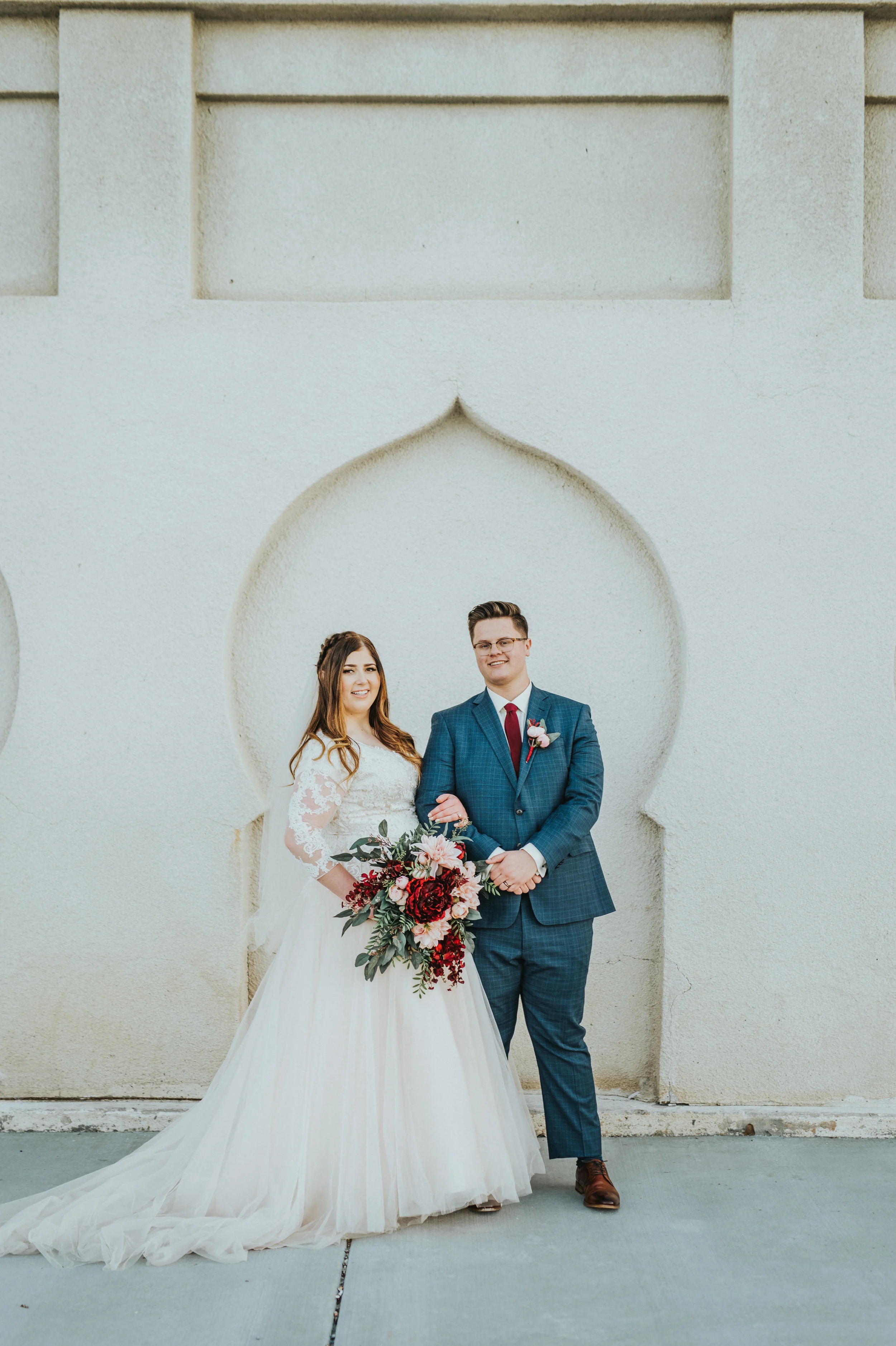  husband and wife under a beautiful arch wedding attire inspiration for brides and grooms simple couple pose inspiration wedding aesthetic inspiration formal wedding photo shoot modest wedding dress #ldswedding #mormon #utah #saltlakecity #formalwedd