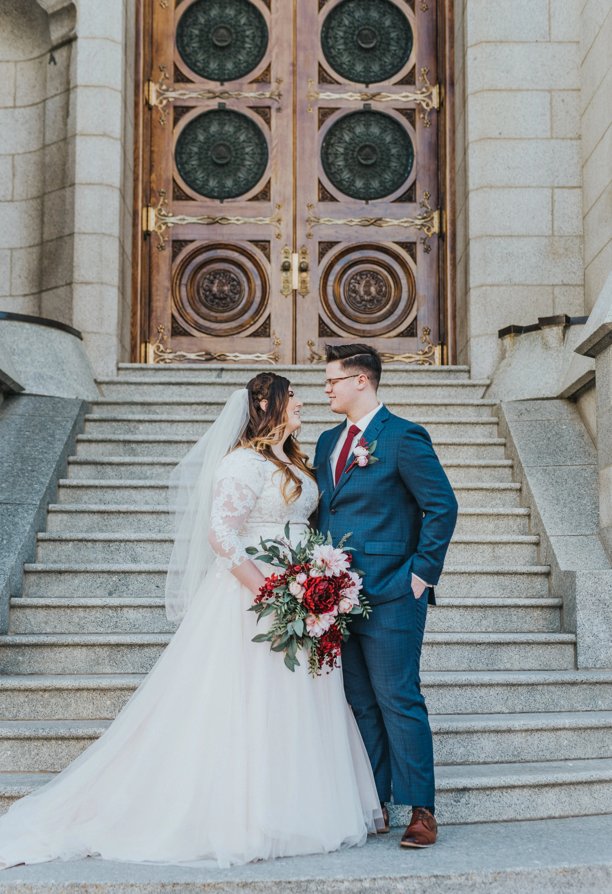 salt lake wedding photographer salt lake temple temple steps may wedding bride and groom husband and wife sealed for eternity classy wedding style lace wedding dress long sleeve wedding dress ball gown wedding dress blue wedding suit blue and red we
