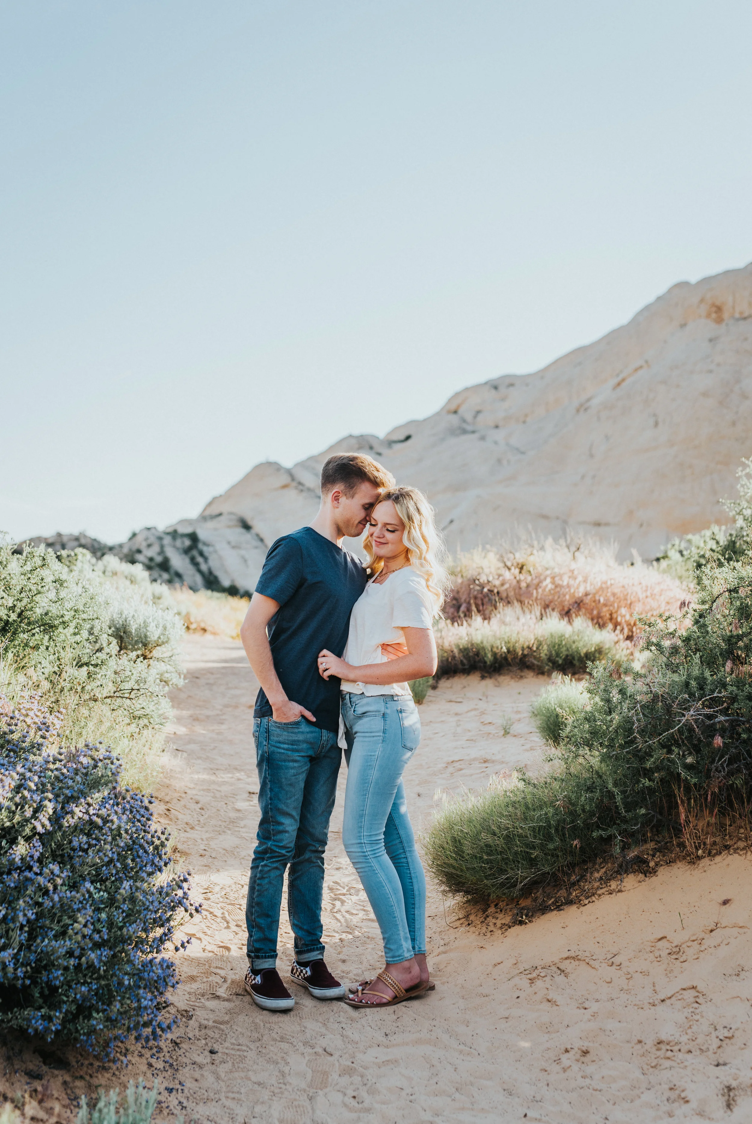  dirt pathway mountain backdrop dessrt engagement session snow canyon utah saint george utah northern utah photographer holding hands playful candid photos neutral family pictures color scheme #saintgeorgephotography #snowcanyon #engagementsession #u