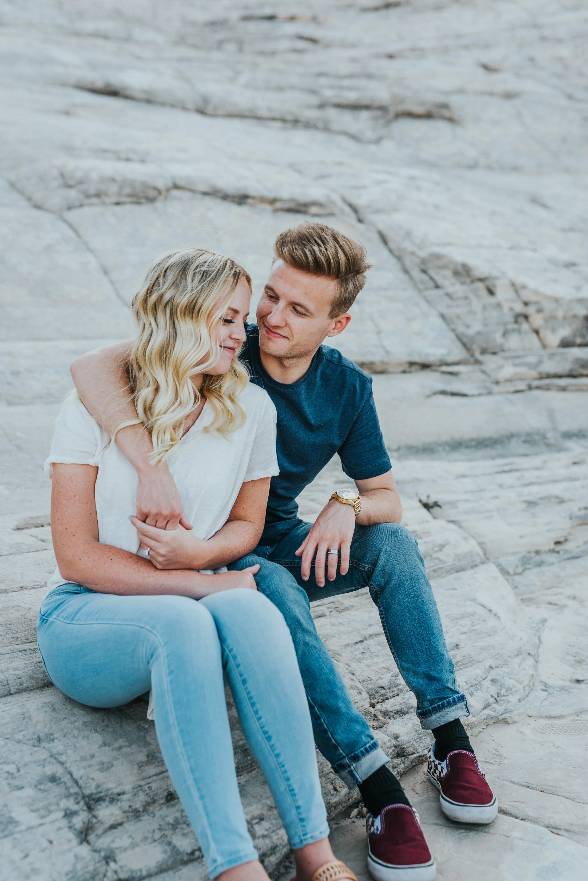  rocky background mountains sitting cuddling smiling happy exploring utah northern utah professional photography jeans tshirts hair inspiration natural posing #saintgeorgephotography #snowcanyon #engagementsession #utah #hairinspiration #outfitinspo 