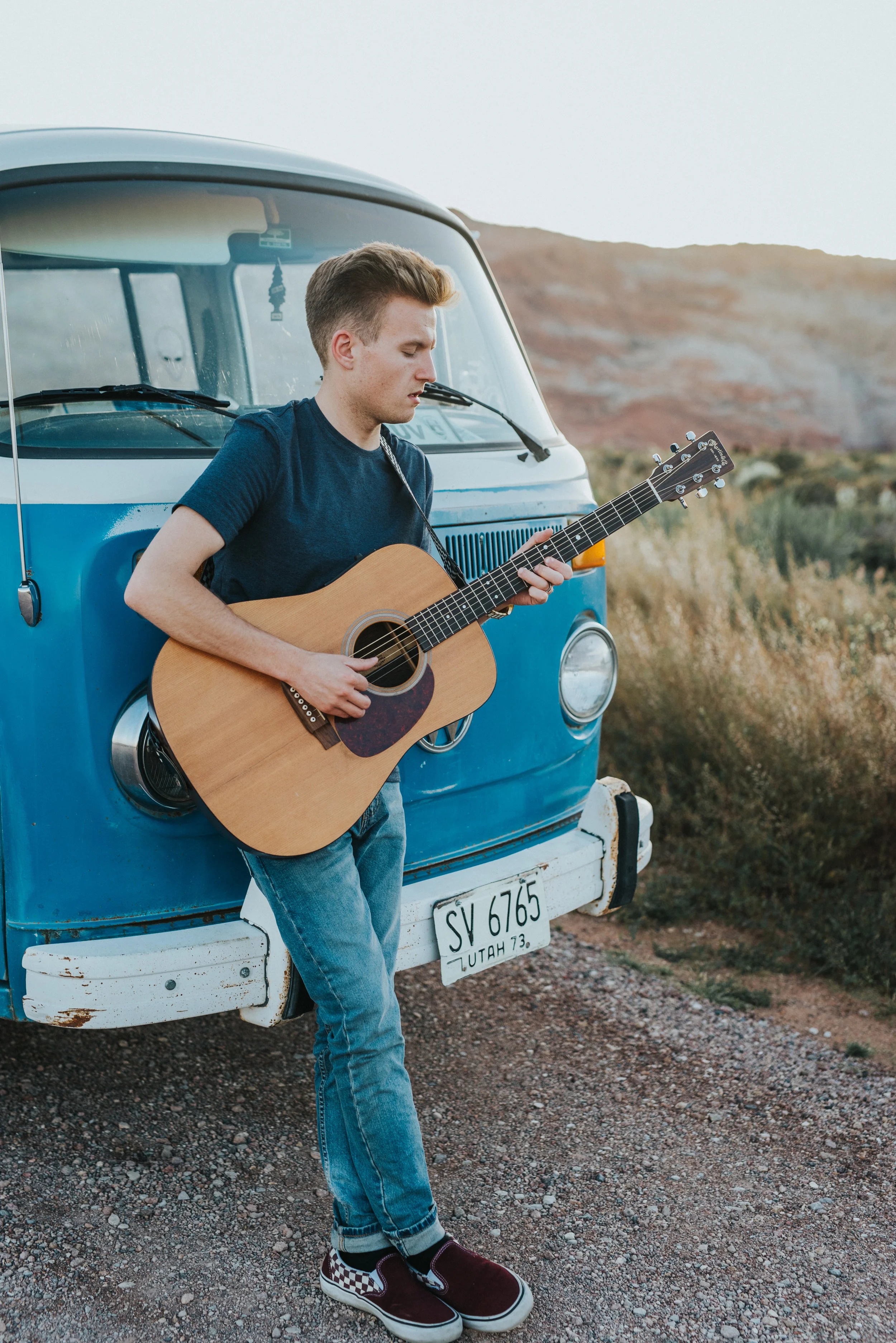  VW van engagement session singing guitar desert photos fiance blue van vintage remodel snow canyon utah saint george utah tall grass mountain jeans tshirt northern utah photography #saintgeorgephotography #snowcanyon #engagementsession #utah #hairin