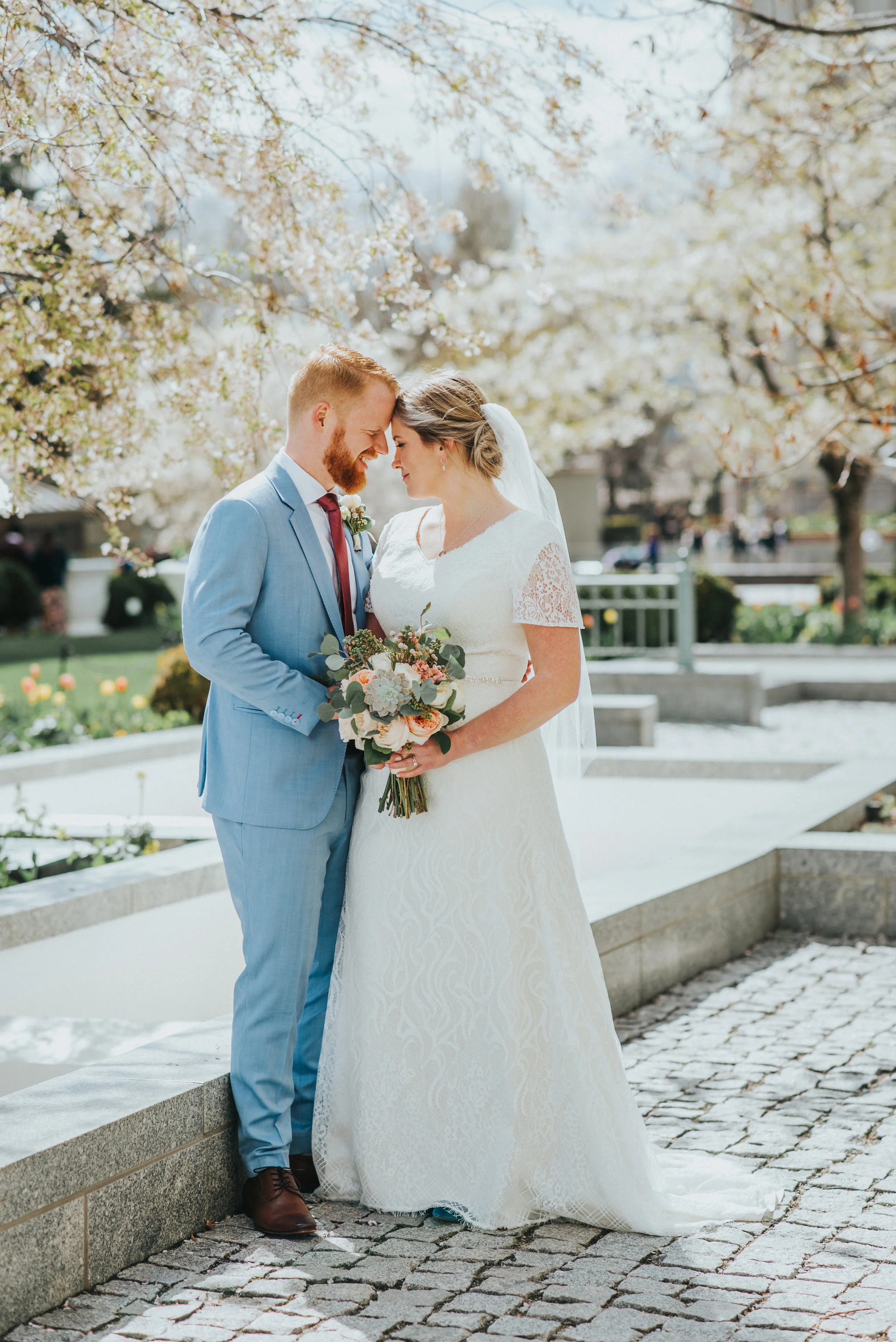  norther utah professional wedding photographer salt lake city utah salt lake city temple grounds couple photos pastel wedding colors blue wedding suit hugging smiling romantic red tie #northernutahweddingphotographer #saltlakecityphotographer #weddi