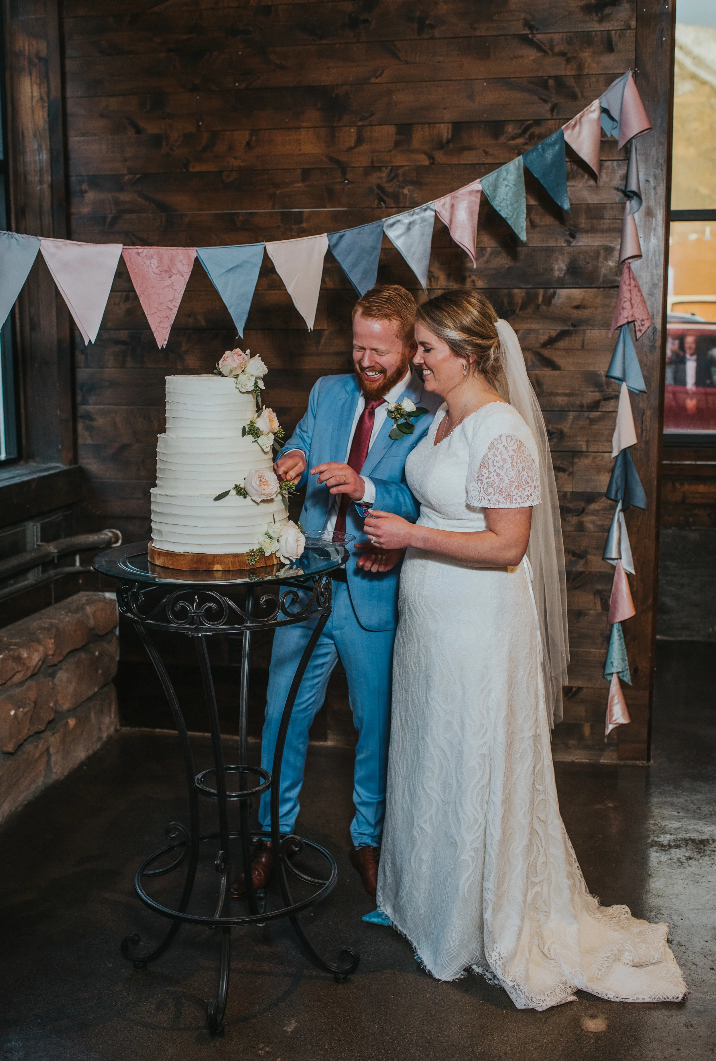  knot and pine alpine barn wedding reception northern utah professional wedding photography cake cutting happy wedding celebration pastel wedding decorations modest lace wedding dress powder blue wedding suit rustic wedding #northernutahweddingphotog