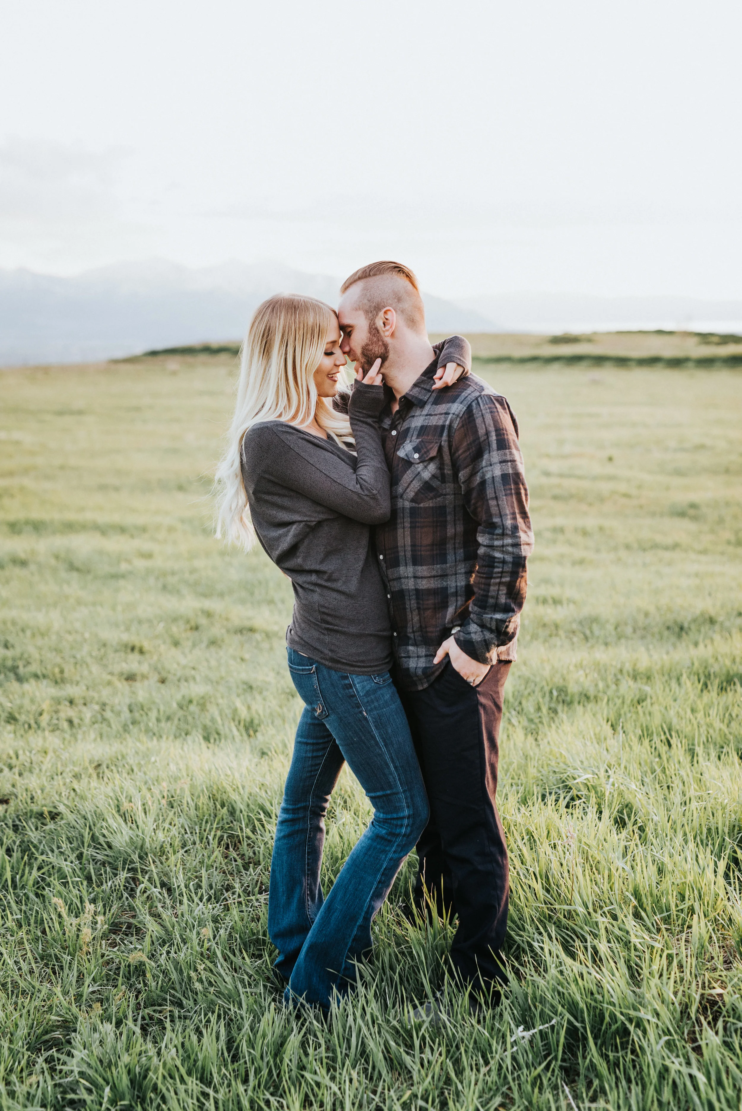  green fields nature engagement session logan utah photographer fall colored outfit inspiration hugging kissing romantic couple photos northern utah engagement photographer true to color photography cache valley utah tunnel springs utah mountain back