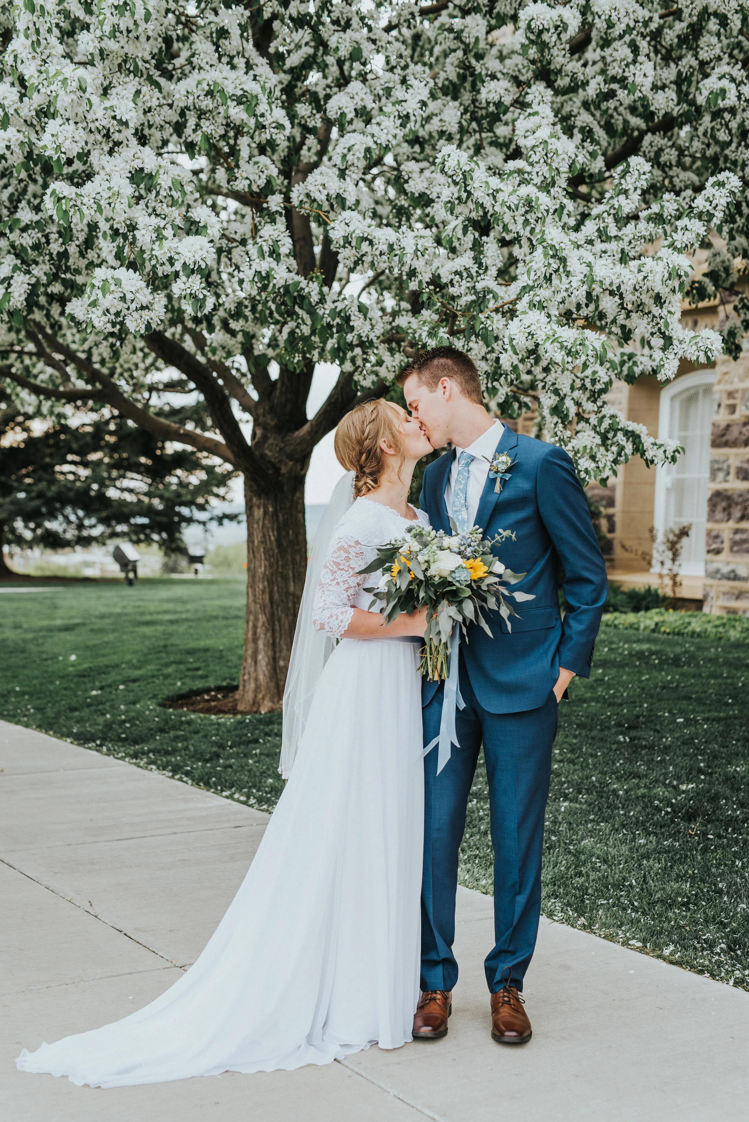  spring wedding blossoming tree kissing romantic wedding bouquet sunflower blue and white wedding colors navy wedding suit modest wedding dress logan utah temple best cache valley wedding photographer wedding formals #Loganutah #cachevalleyphotograph
