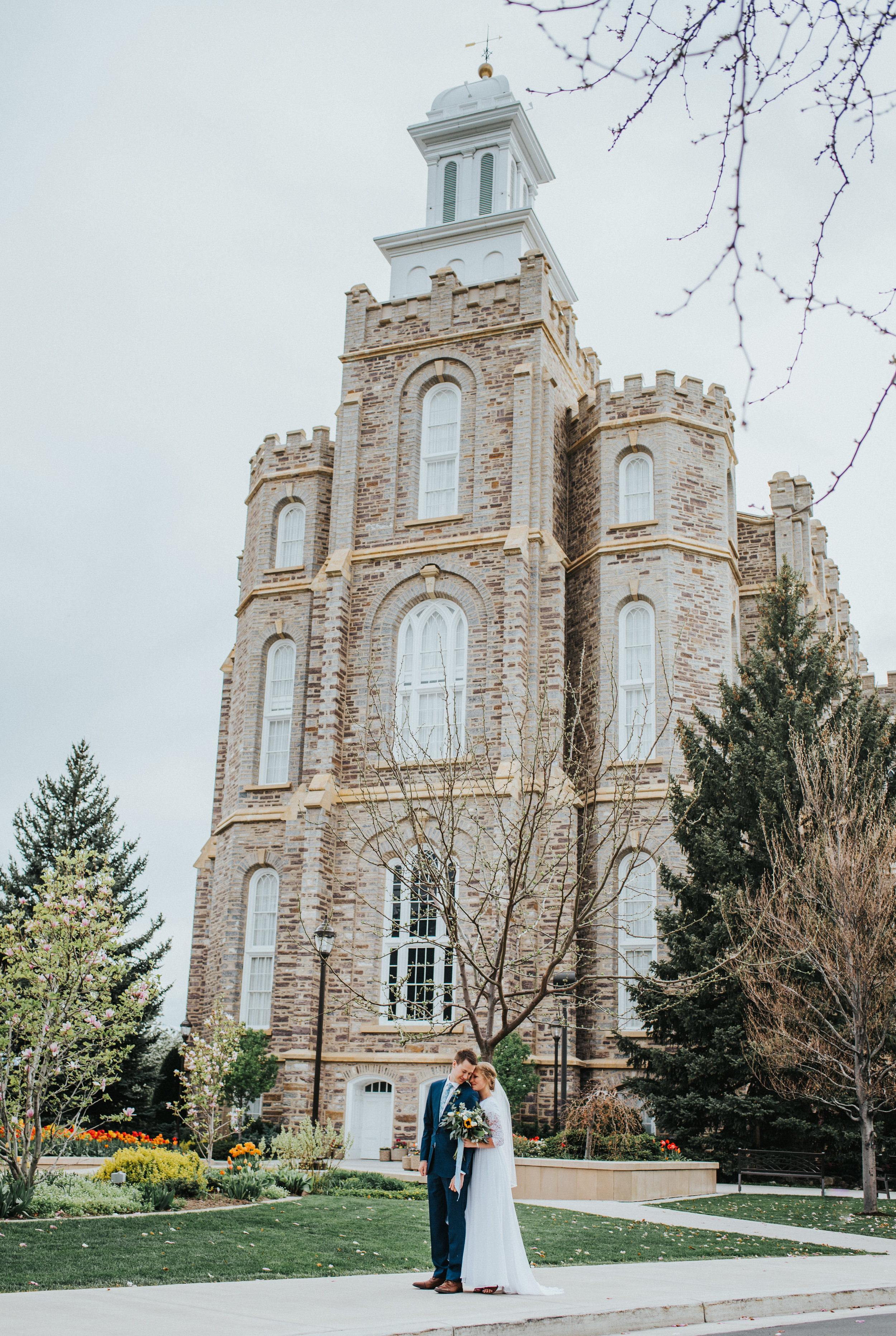  overcast sky logan utah lds temple wedding hugging leaning in foreheads touching candid wedding poses temple grounds walking cache valley wedding photographer #Loganutah #cachevalleyphotographer #Ido #Isaidyes #weddingformals #weddinginspo #utah #ut