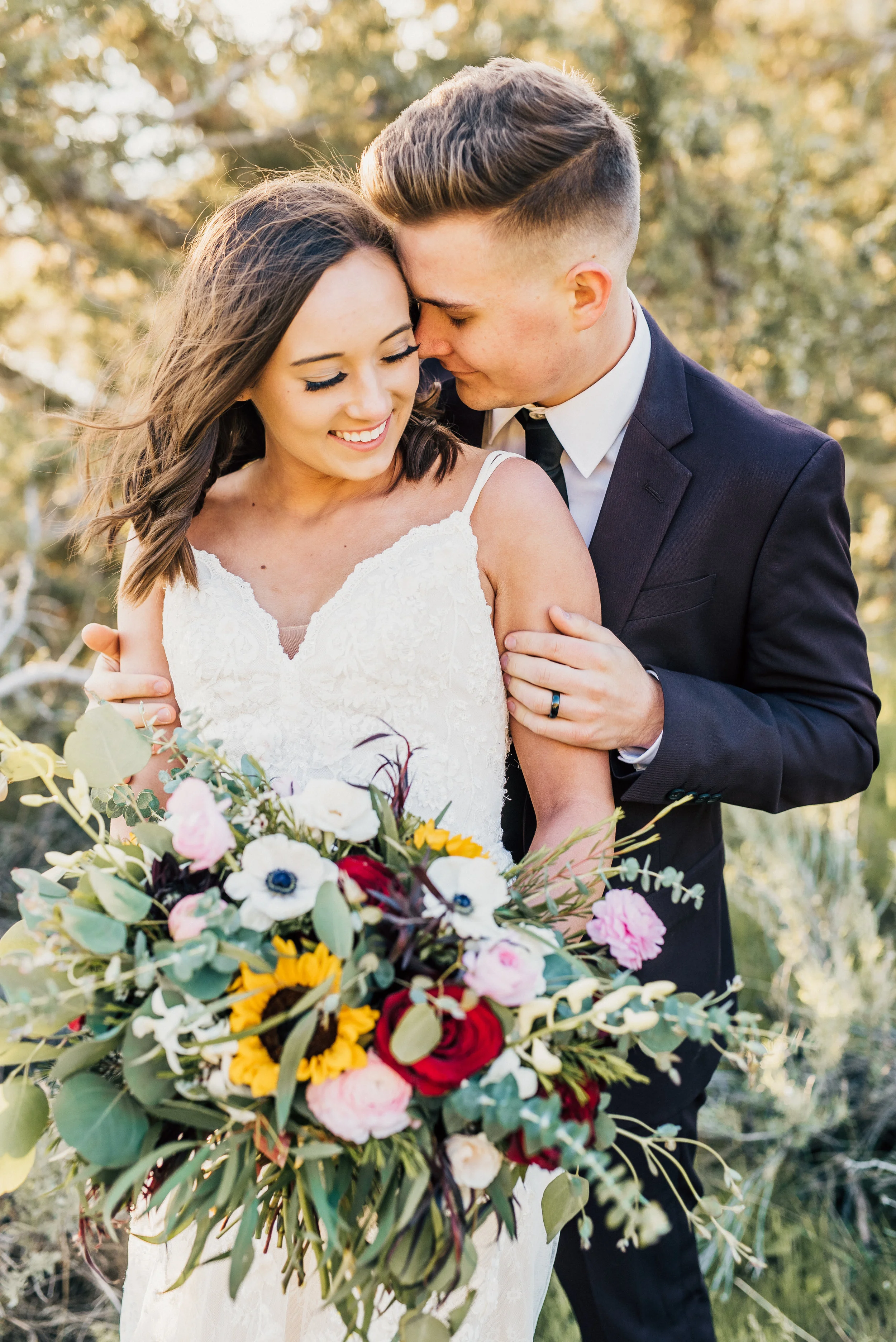 foreheads touching hugging smiling romantic whispering loosely packed wildflower bouquet strappy lace wedding dress bohemian themed wedding black suit northern utah wedding photographer #greencanyon #northernutahweddingphotographer #bohemianwedding 