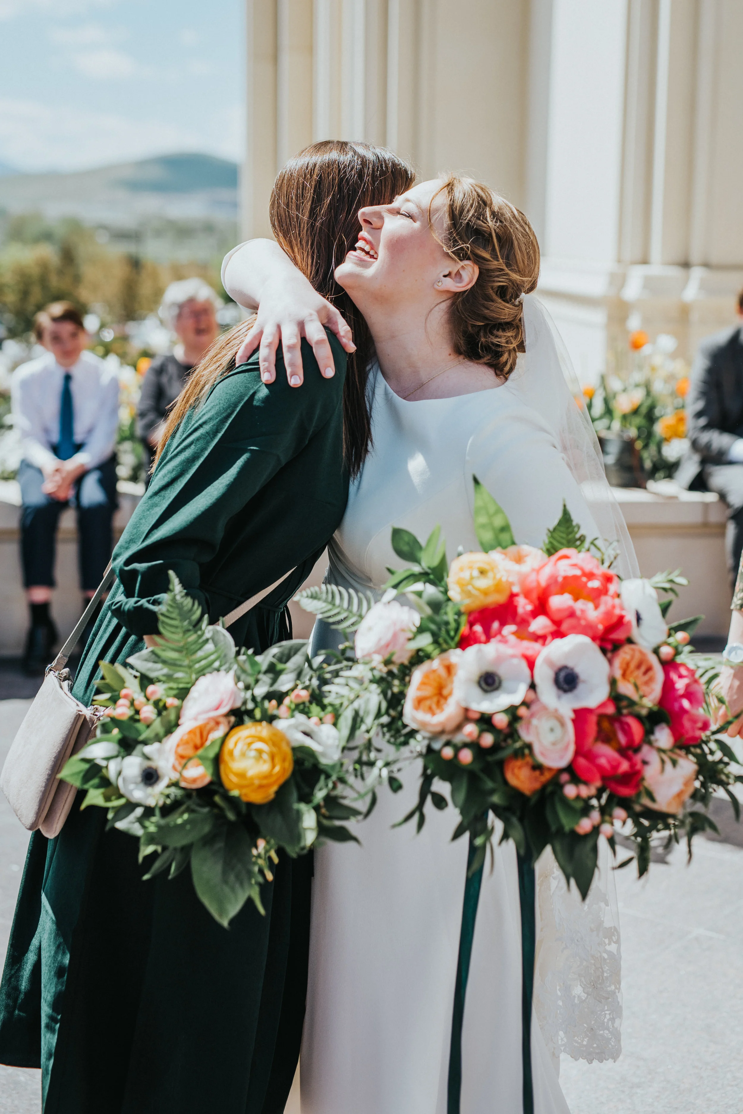  payson utah lds temple wedding exit hugging happy celbrating emerald green bridesmaids dreses poppy pink peach floral wedding bouquet bride happy smiling hugging payson utah wedding photographer #professionalutahphotographer #paysonutah #northampton