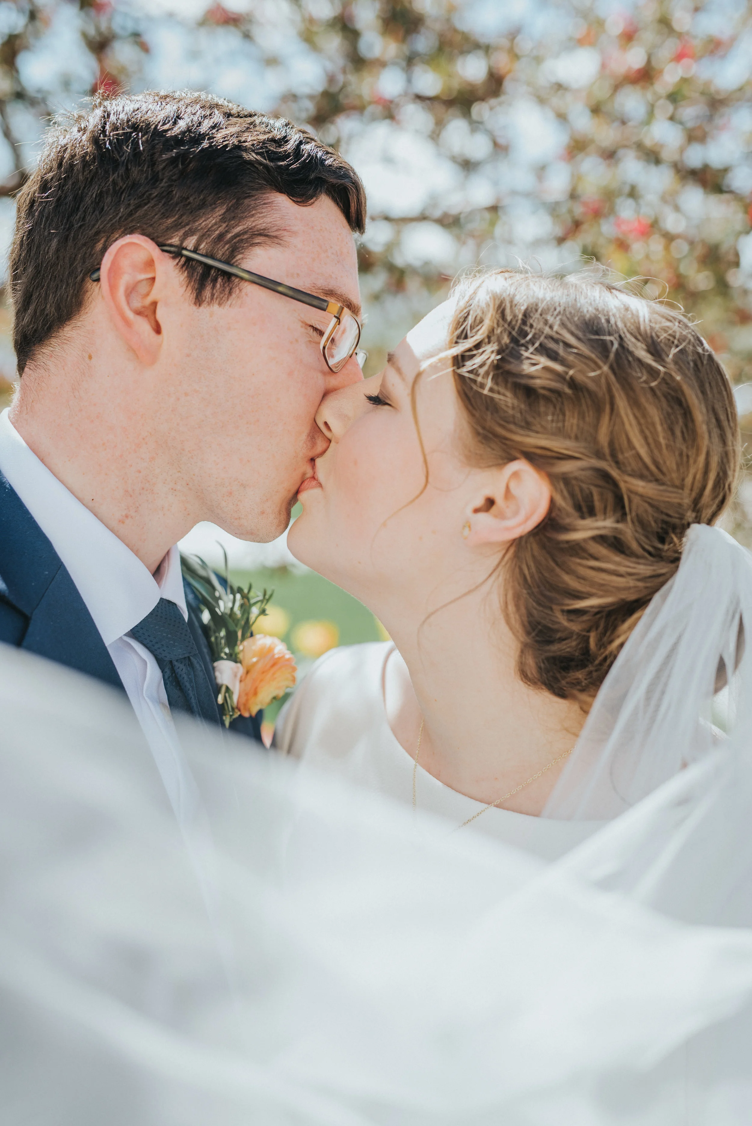  messy curled wedding updo whispy billowy wedding veil kissing romantic just married peach boutonniere wedding hair inspiration payson utah professional wedding photographer candid photos #professionalutahphotographer #paysonutah #northamptonhouse #i