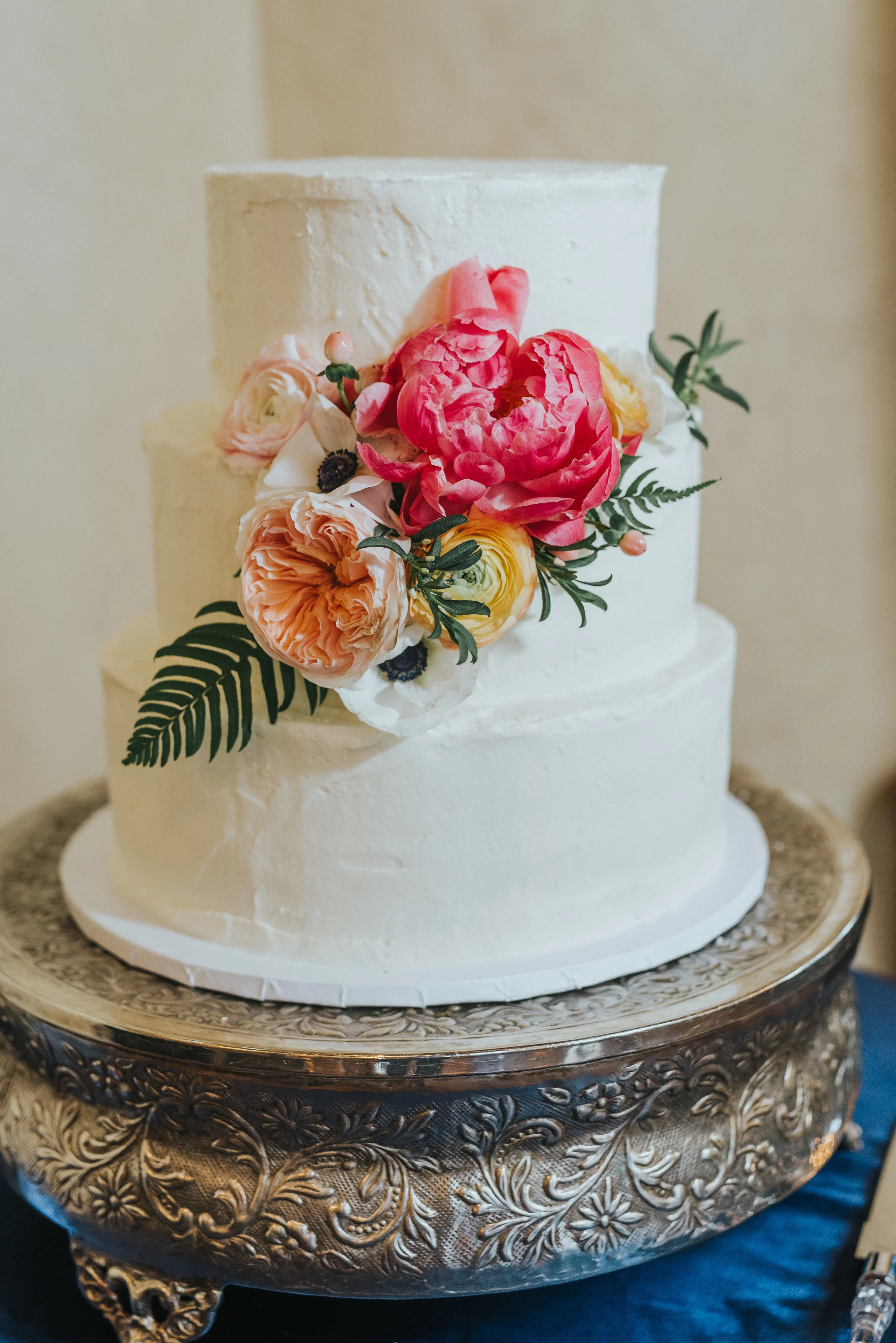  simple rustic white three tiered wedding dress floral poppy and pink floral cake garnish wood cake pedestal wedding reception northampton house payson utah best payson utah wedding photographer #professionalutahphotographer #paysonutah #northamptonh