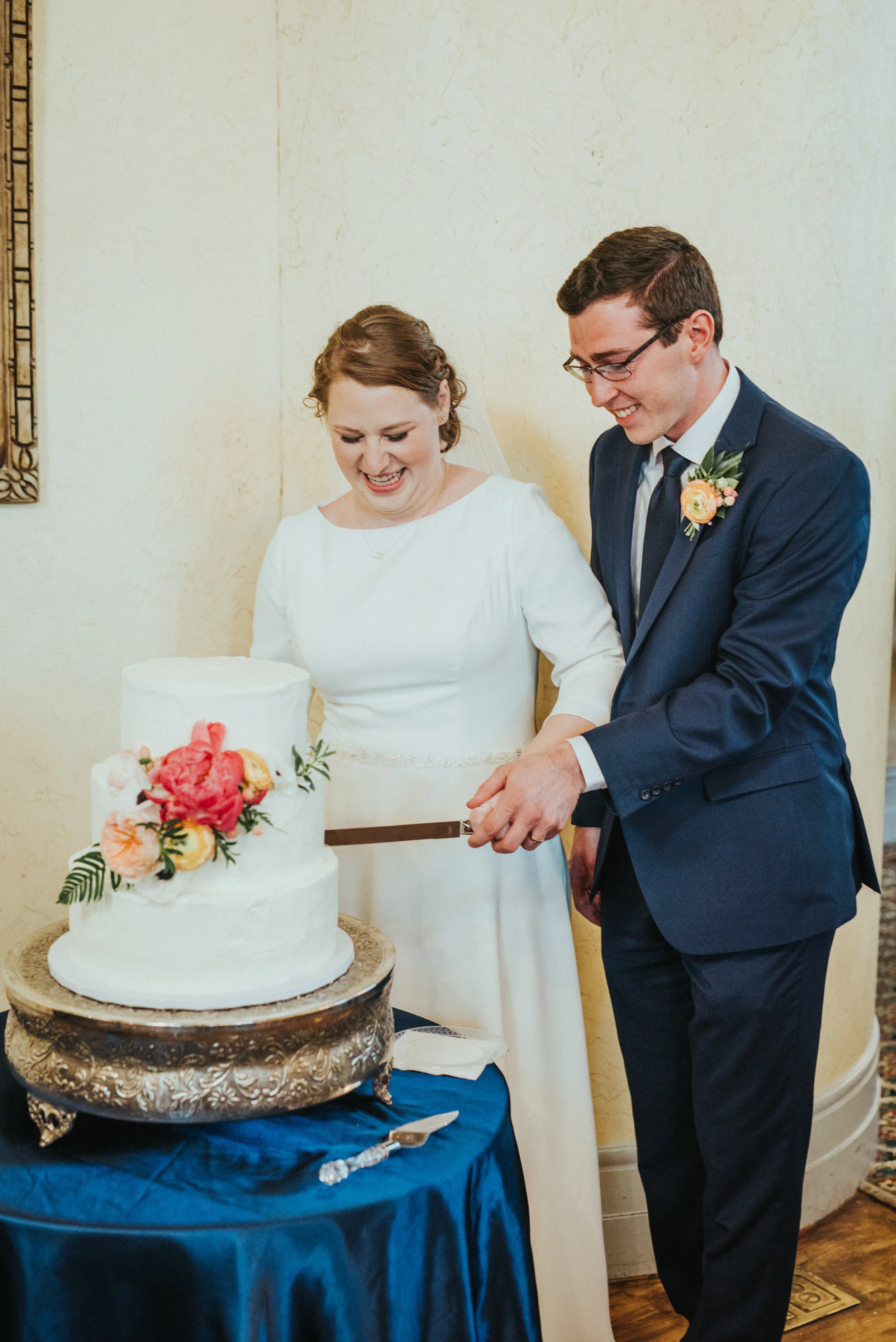  northampton house payson utah wedding reception cake cutting three tiered rustic wedding cake floral cake garnishing pink wedding colors navy wedding suit holding hands happy celebrating best payson utah wedding photographer #professionalutahphotogr