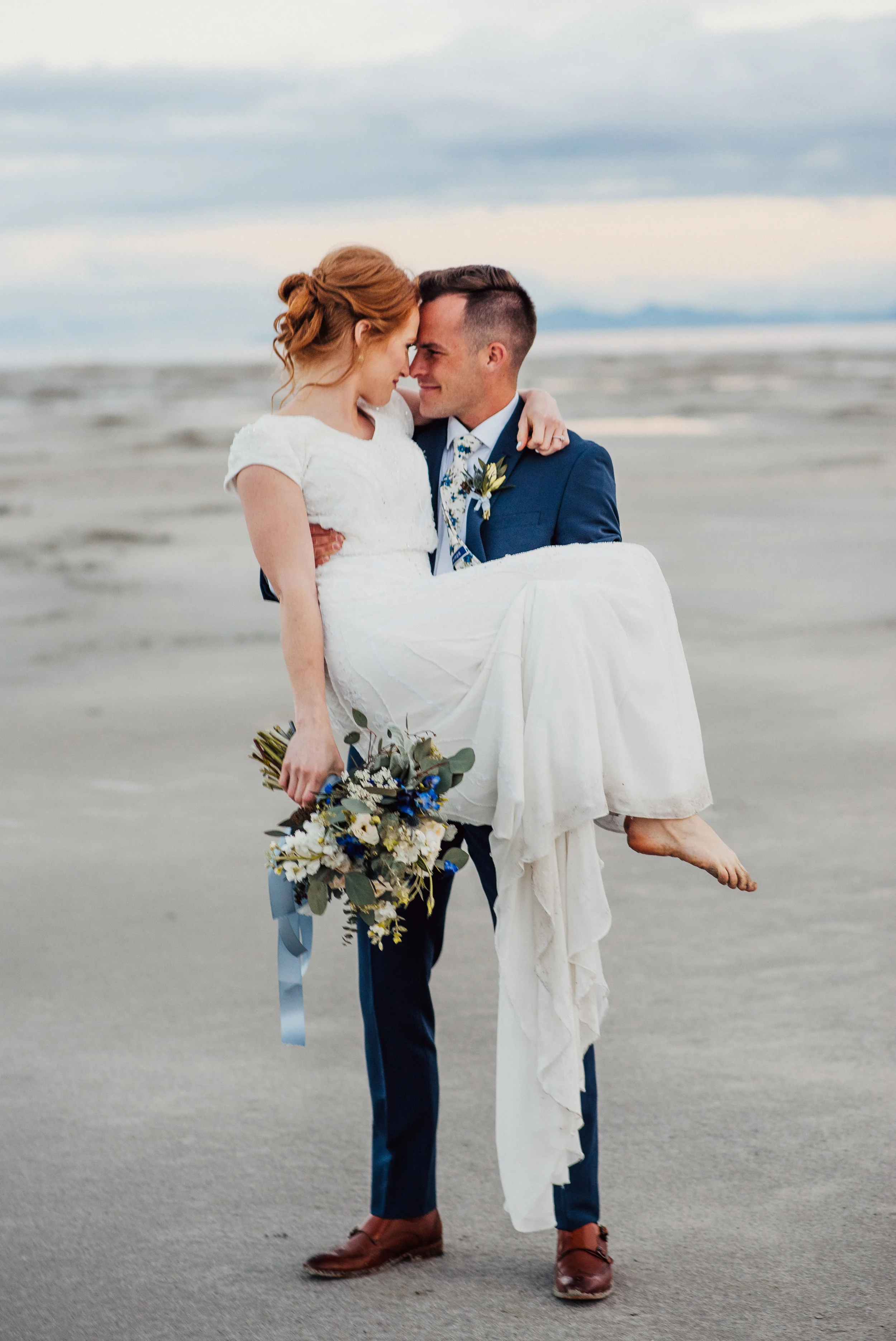 cuddling holding the bride wet wedding dress neutral floral bouquet navy wedding suit great salt lake northern utah wedding photographer red hair inspiration wedding updo #spiraljetty #saltlakecityweddingphotographer #saltlake #ido #northernutahphot