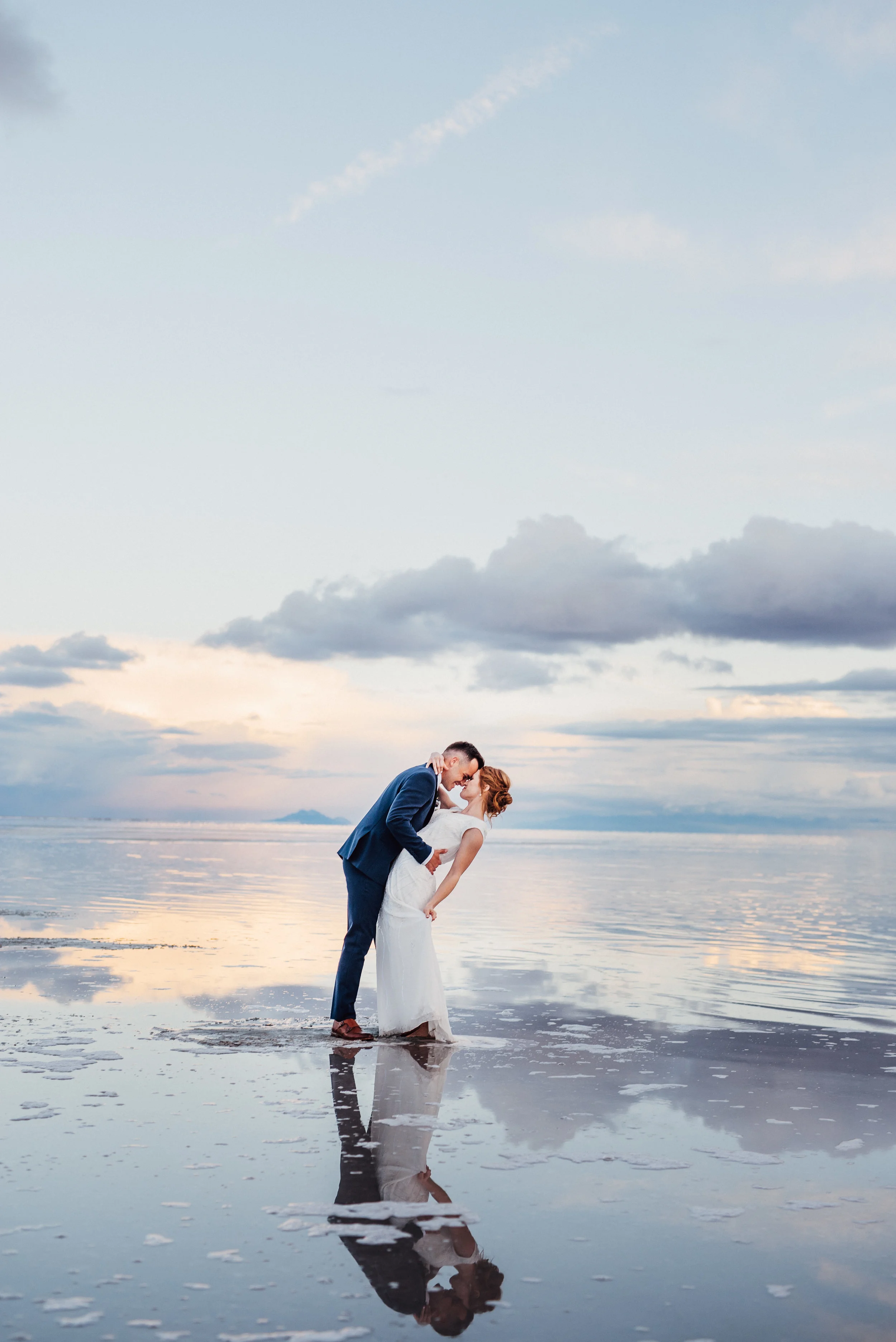  dramatic bridal session dipping kissing sunset overlooking water romantic walking in water wet wedding dress navy suit modest wedding dress northern utah photographer professional #spiraljetty #saltlakecityweddingphotographer #saltlake #ido #norther