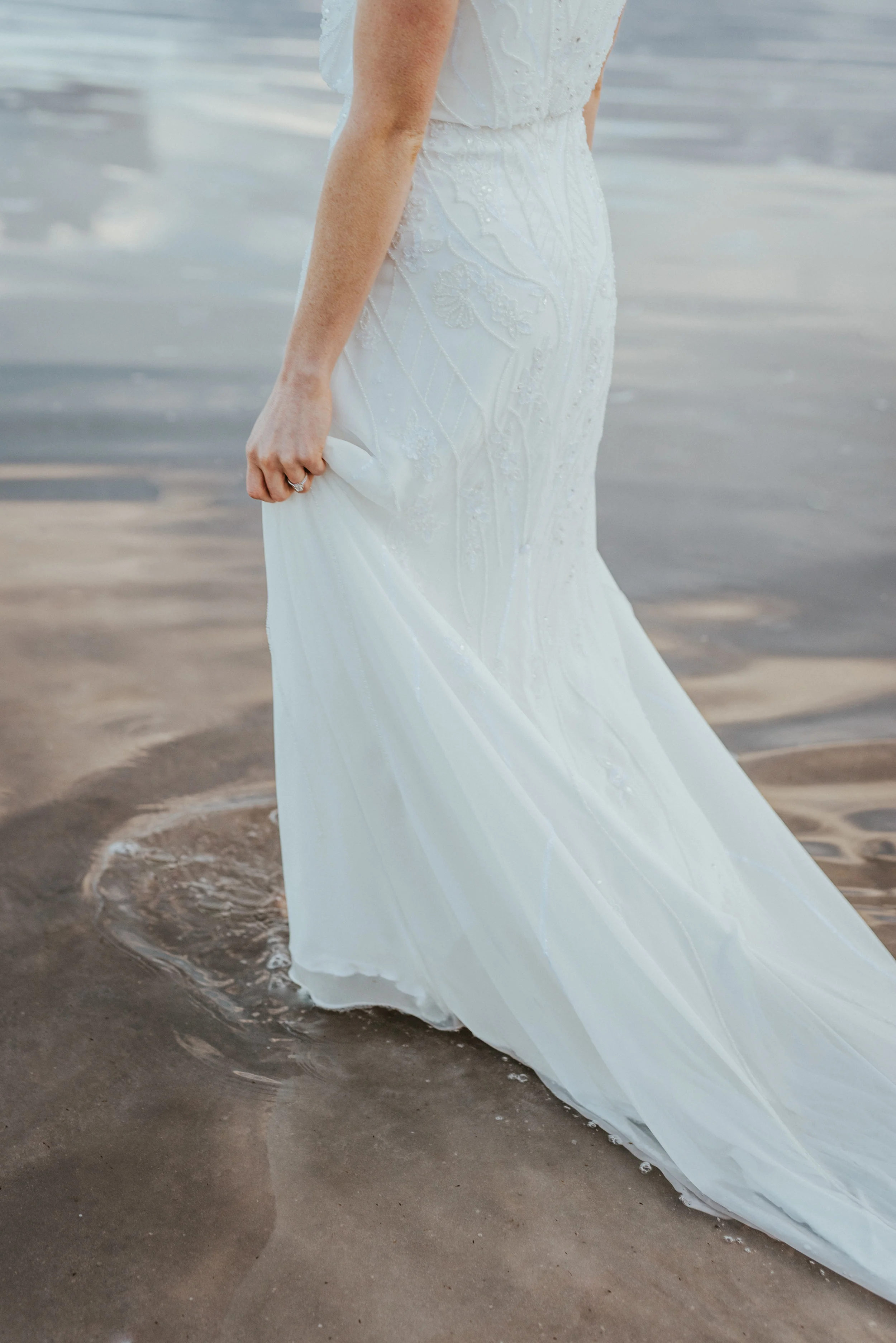  white wedding dress train walking in water holding dress water ripples dramatic romantic formal bridal session northern utah wedding photographer professional great salt lake #spiraljetty #saltlakecityweddingphotographer #saltlake #ido #northernutah