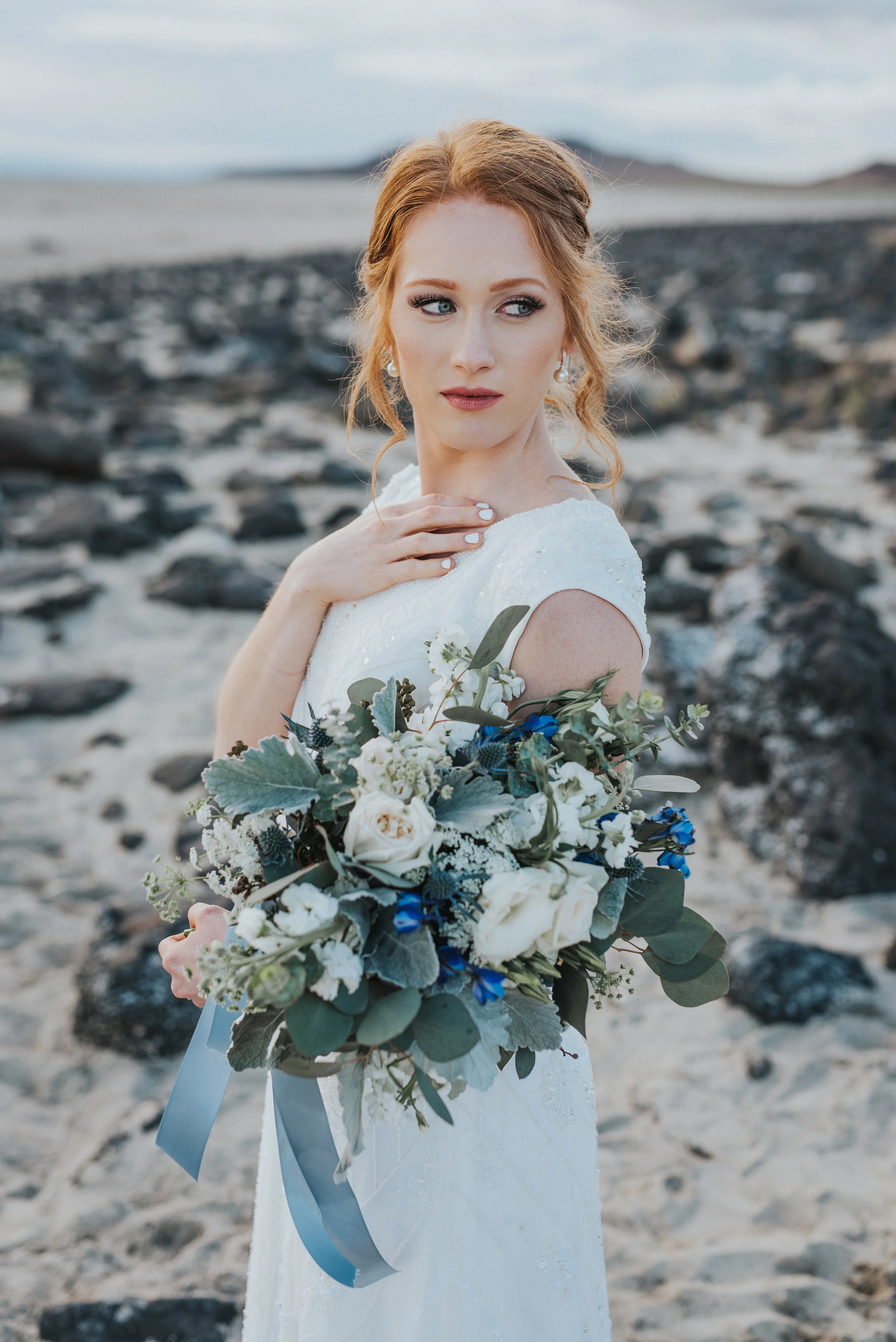  winter themed wedding floral bouquet dusty blue bouquet ribbon red hair bridal updo inspiration looking into distance sandy salt lake wedding photographer #spiraljetty #saltlakecityweddingphotographer #saltlake #ido #northernutahphotographer #bridal