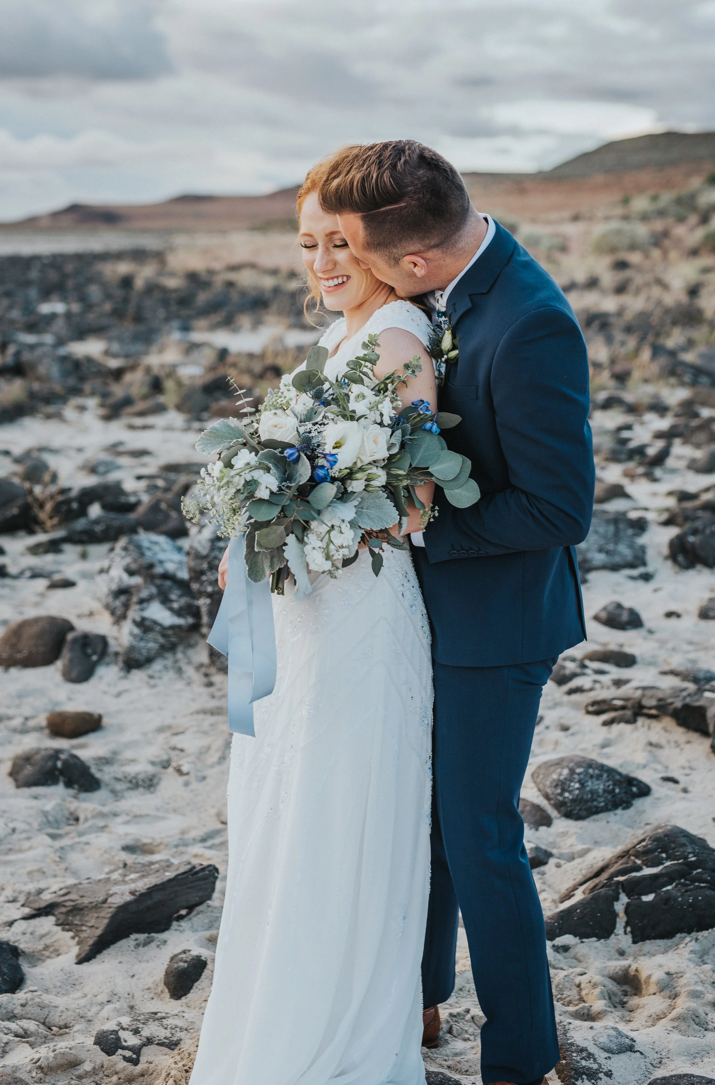  kissing cheeks groom bride navy wedding suit modest white wedding dress the great salt lake sunset bridal portrait session best northern utah wedding photographer #spiraljetty #saltlakecityweddingphotographer #saltlake #ido #northernutahphotographer