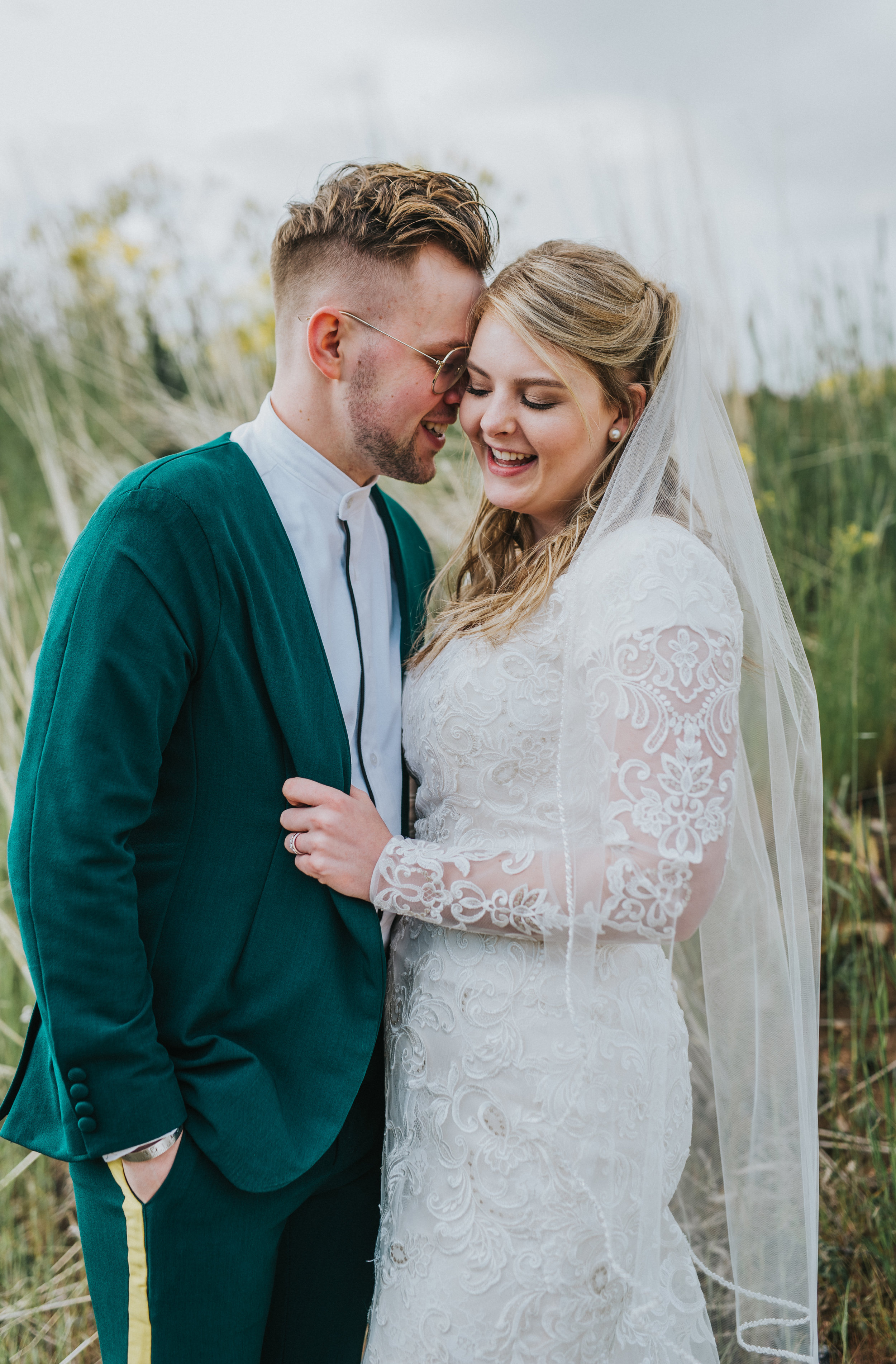  cuddling hugging tall grass hyrum reservoir hyrum utah logan utah cache valley northern utah wedding photographer formals wedding lace wedding dress modest green wedding suit yellow retro striped pants vintage glasses #cachevalleyutah #hyrumutah #no