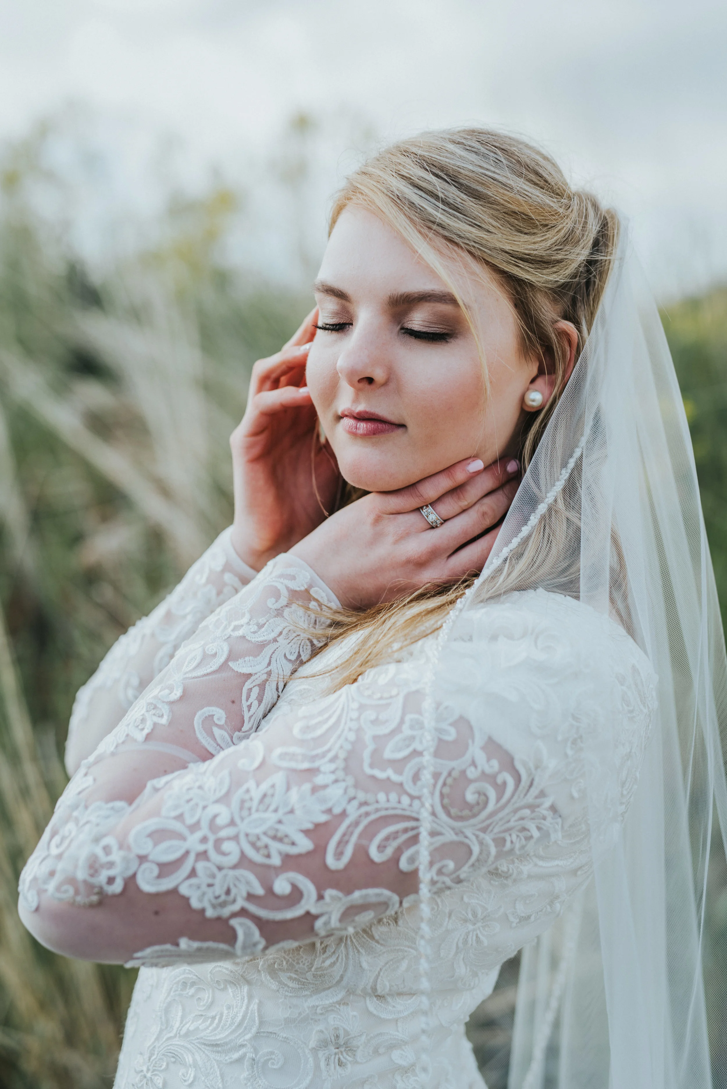  romantic bridal portrait bride to be modest lace wedding dress long veil touching cheek soft elegant timeless pearl earrings northern utah wedding photographer logan utah cache valley #cachevalleyutah #hyrumutah #northernutahphotographer #bridals #h