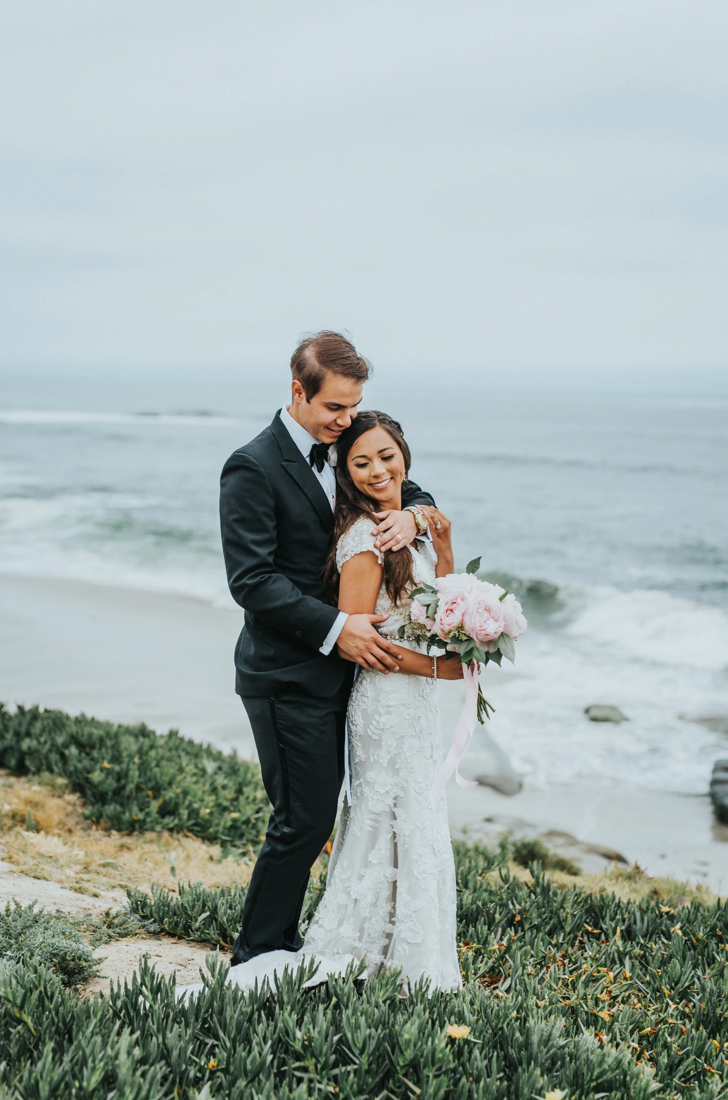  smiling head on chest hugging embracing la jolla overcast beach cliffs loose wedding curls hair inspiration romantic newlyweds northern utah wedding photographer san diego wedding photography #lajollacaliforniaweddingphotographer #sandiegotemple #wi