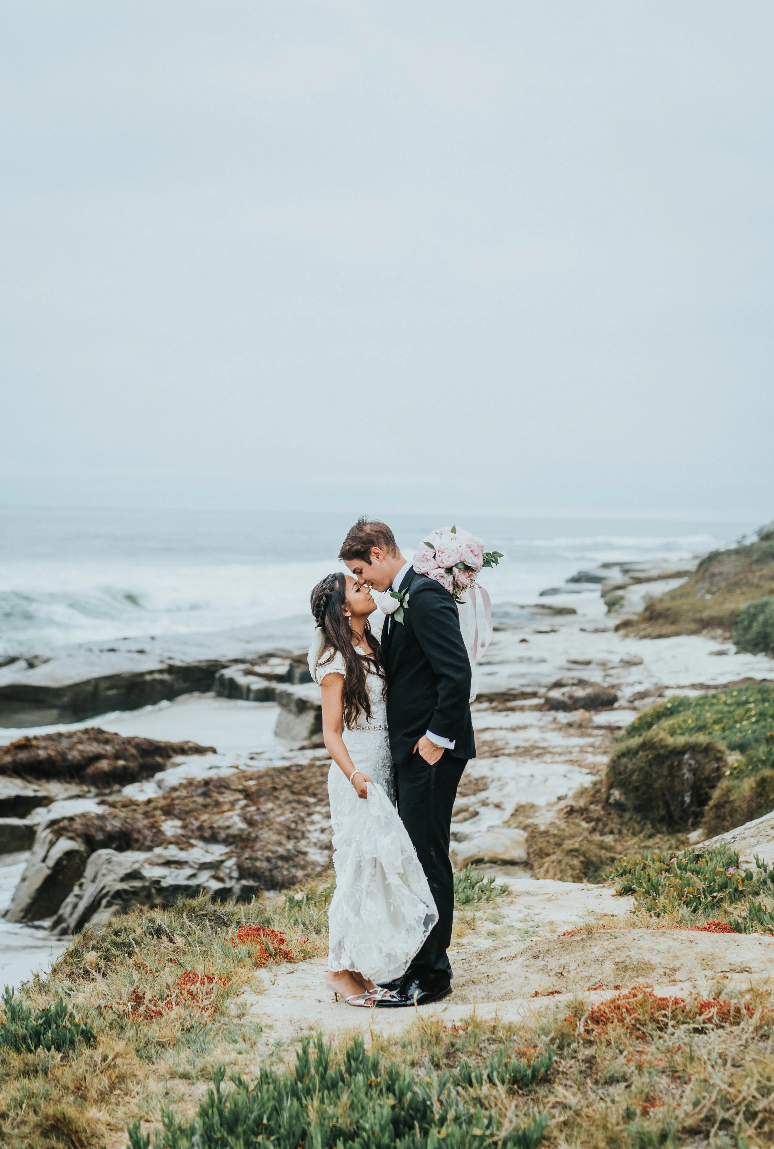  touching foreheads smiling romantic embracing wedding day windansea beach cliffs overcast beach skies san diego california wedding photography northern utah wedding photographer  #lajollacaliforniaweddingphotographer #sandiegotemple #windanseabeachc