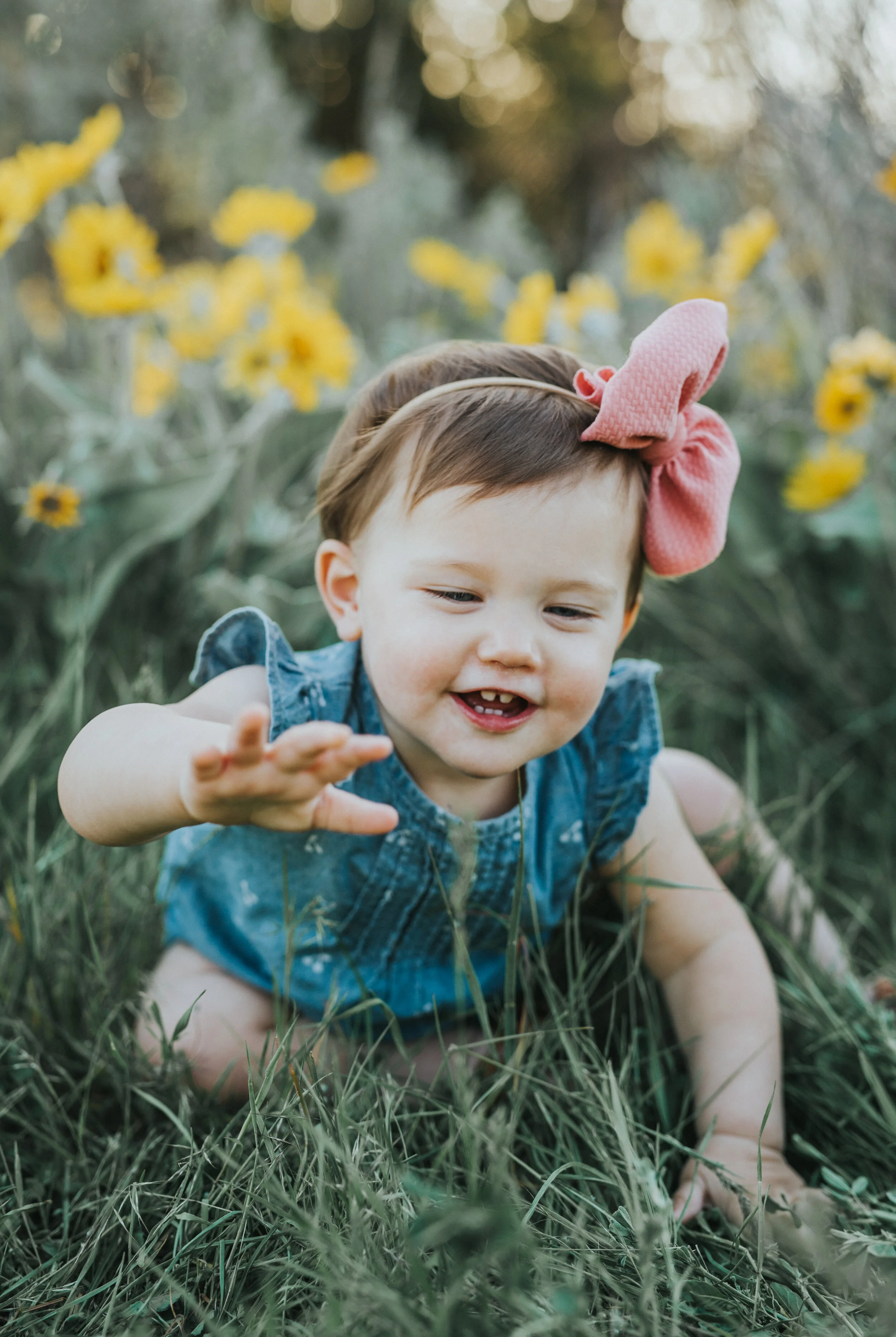  logan utah posing ideas utah photographer family photographer family photography little girl sister hair bow blue and pink outfit ideas for girls semi casual outfit ideas kids sitting in a field portrait session sunflower field crawling kids family 