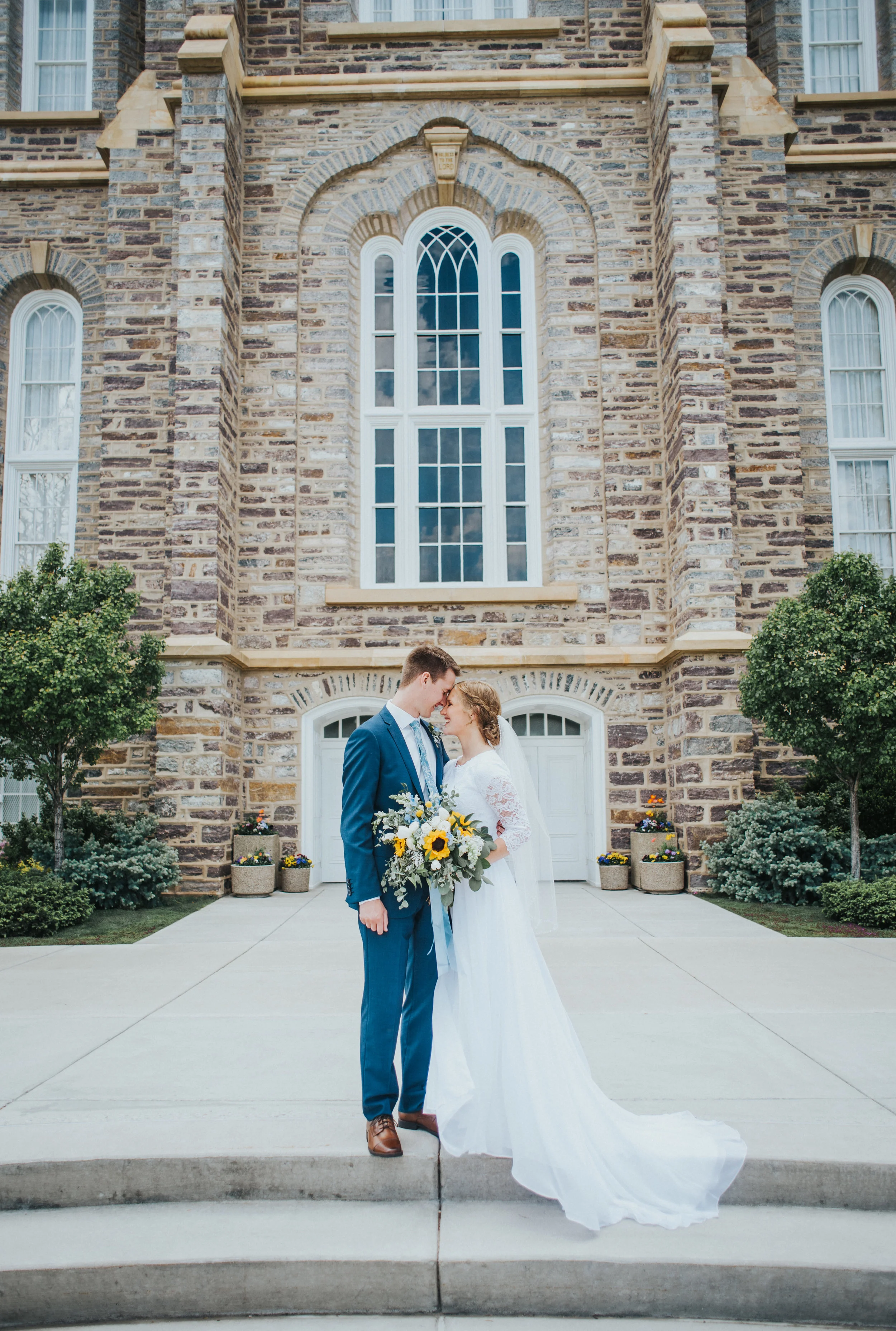  Old rock church wedding professional wedding photographer logan utah stone building foreheads touching modest wedding gown lace long bridal veil navy wedding suit just married topiaries #Loganutah #cachevalleyphotographer #Ido #Isaidyes #oldrockchur