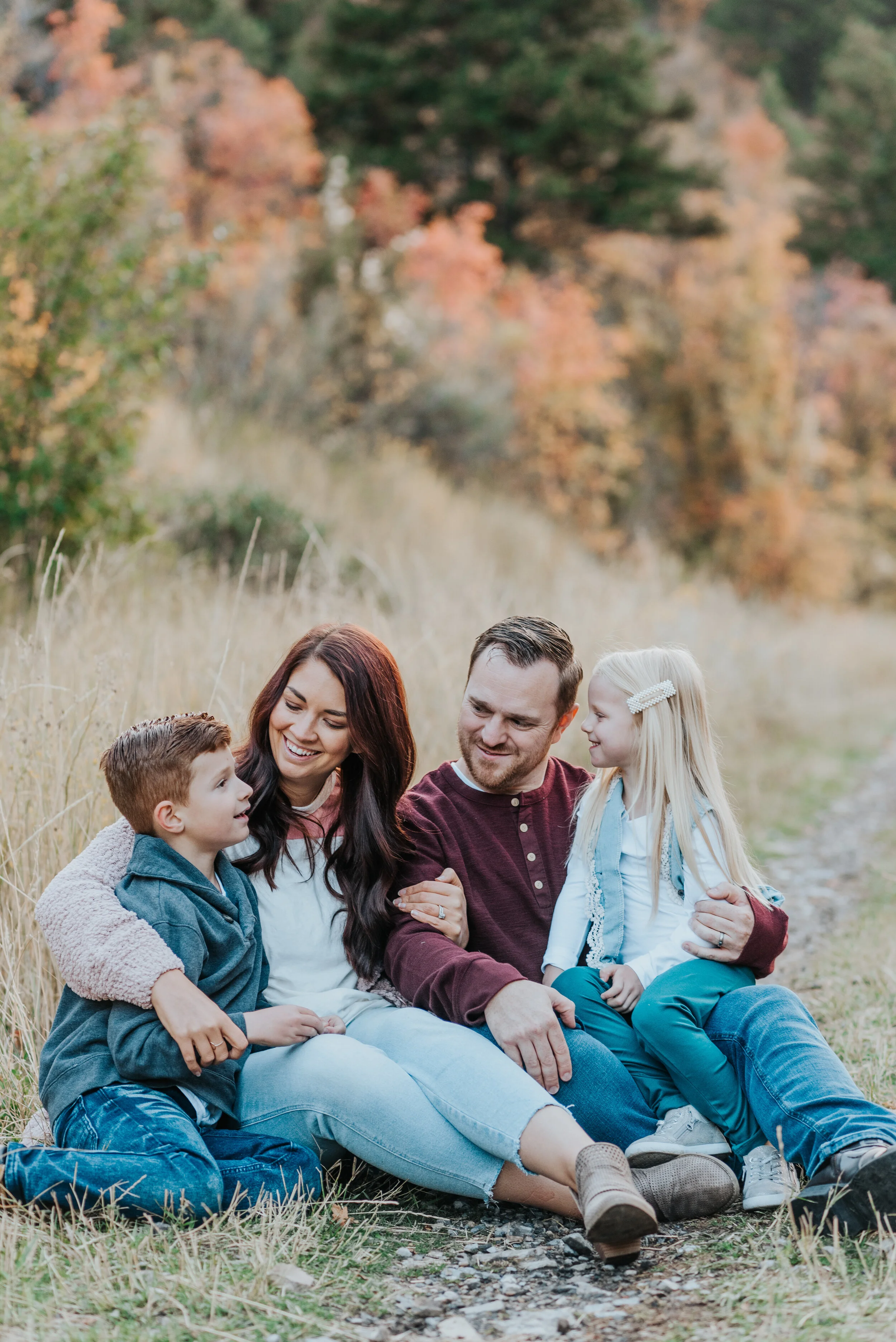  family photos in the mountains fall photos family of four siblings brother and sister cache valley photographer family sitting down on dirt path family of four family posing ideas candid photos silly photos happy family laughing together what to wea