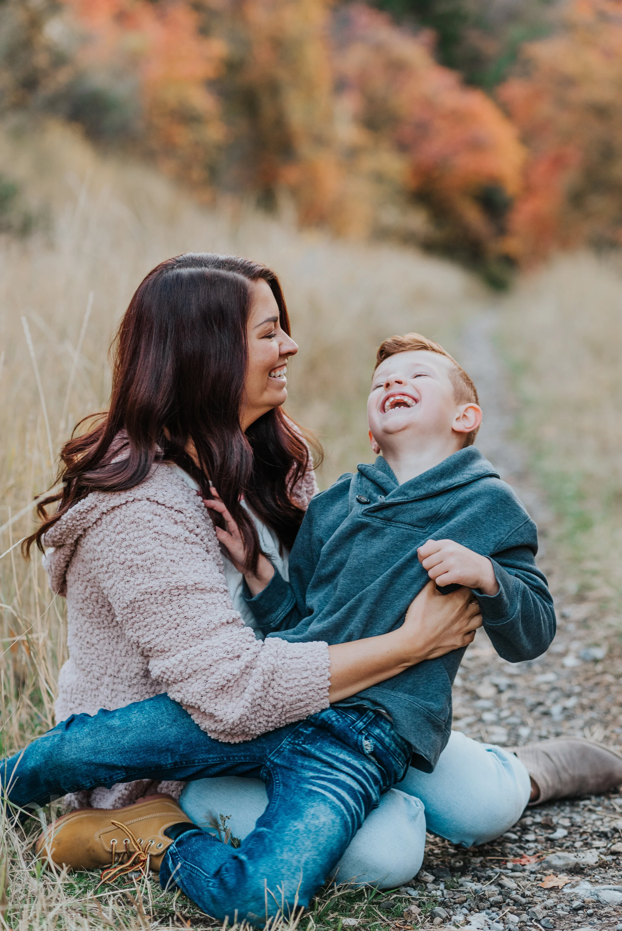  fall leaves fall colors pictures in the mountains family photographer cache valley utah mom and sun silly moments tickle fight fall outfit inspo what to wear to family photos hairstyles for family moments candid moments silly moments playful times b