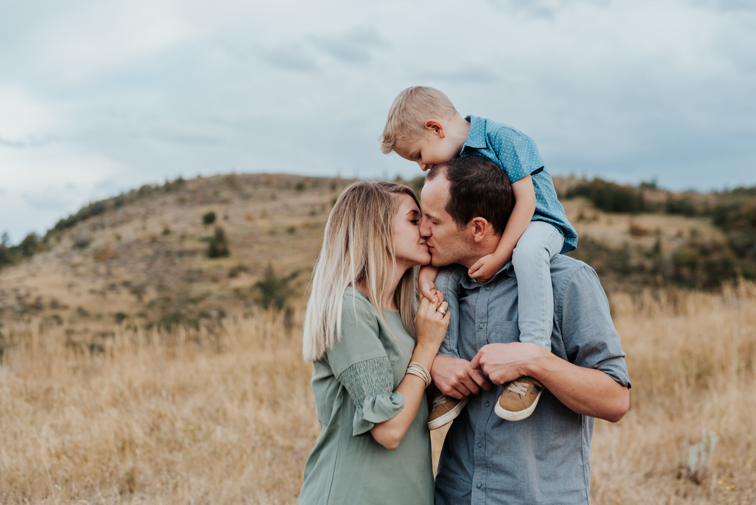  Dad holding his son on his shoulders while his wife gives him a cute kiss in beautiful Cache Valley. baby announcement in family portraits in logan utah cache valley photographers in northern utah professional photographers in utah family pose inspi