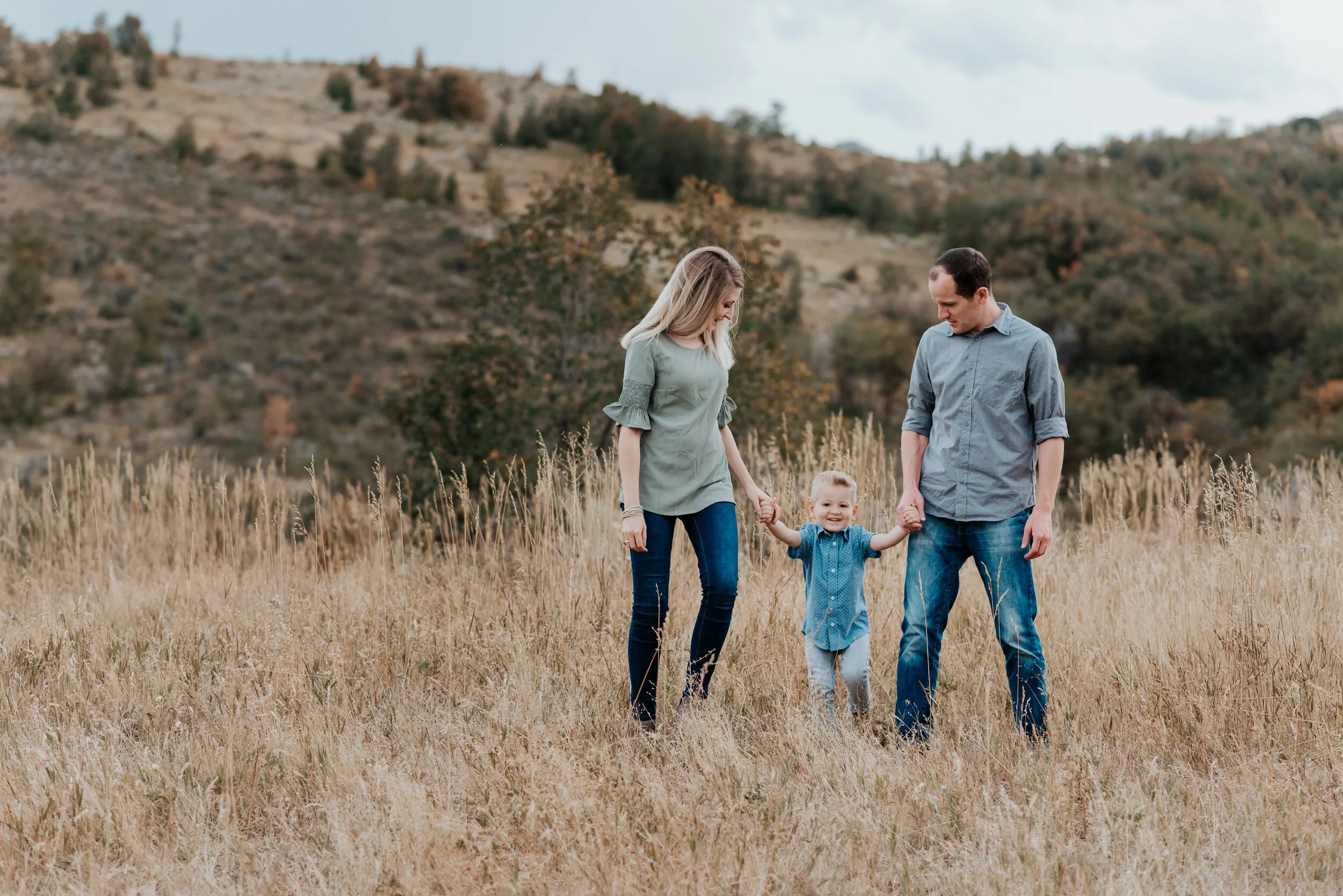 Family of three playing in the mountains near Logan, Utah. sweet parent and children poses baby announcement in family portraits in logan utah cache valley photographers in northern utah professional photographers in utah family pose inspiration cas…
